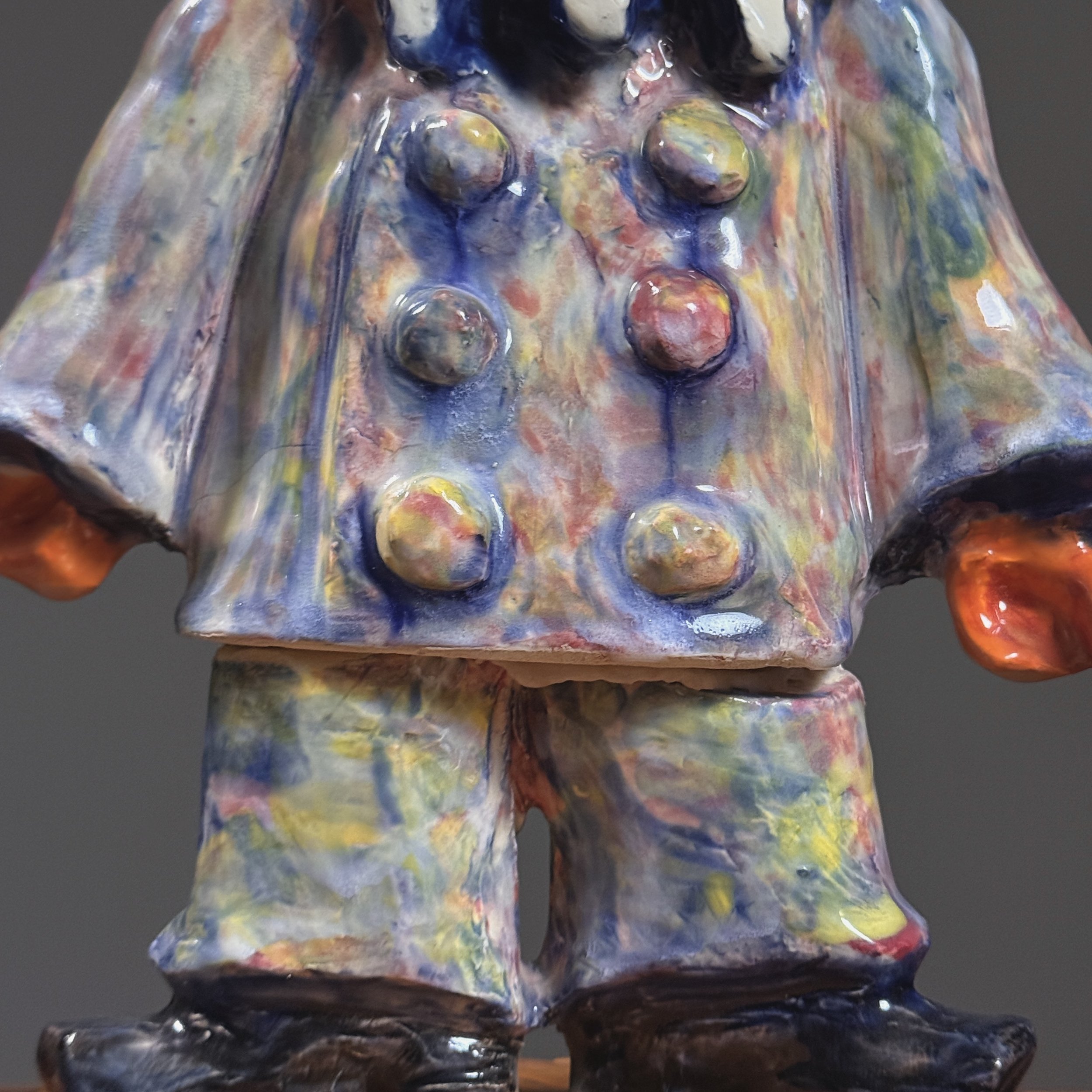 Detail of the figure's hands and costume elements, showcasing Gerber's textured ceramic work.