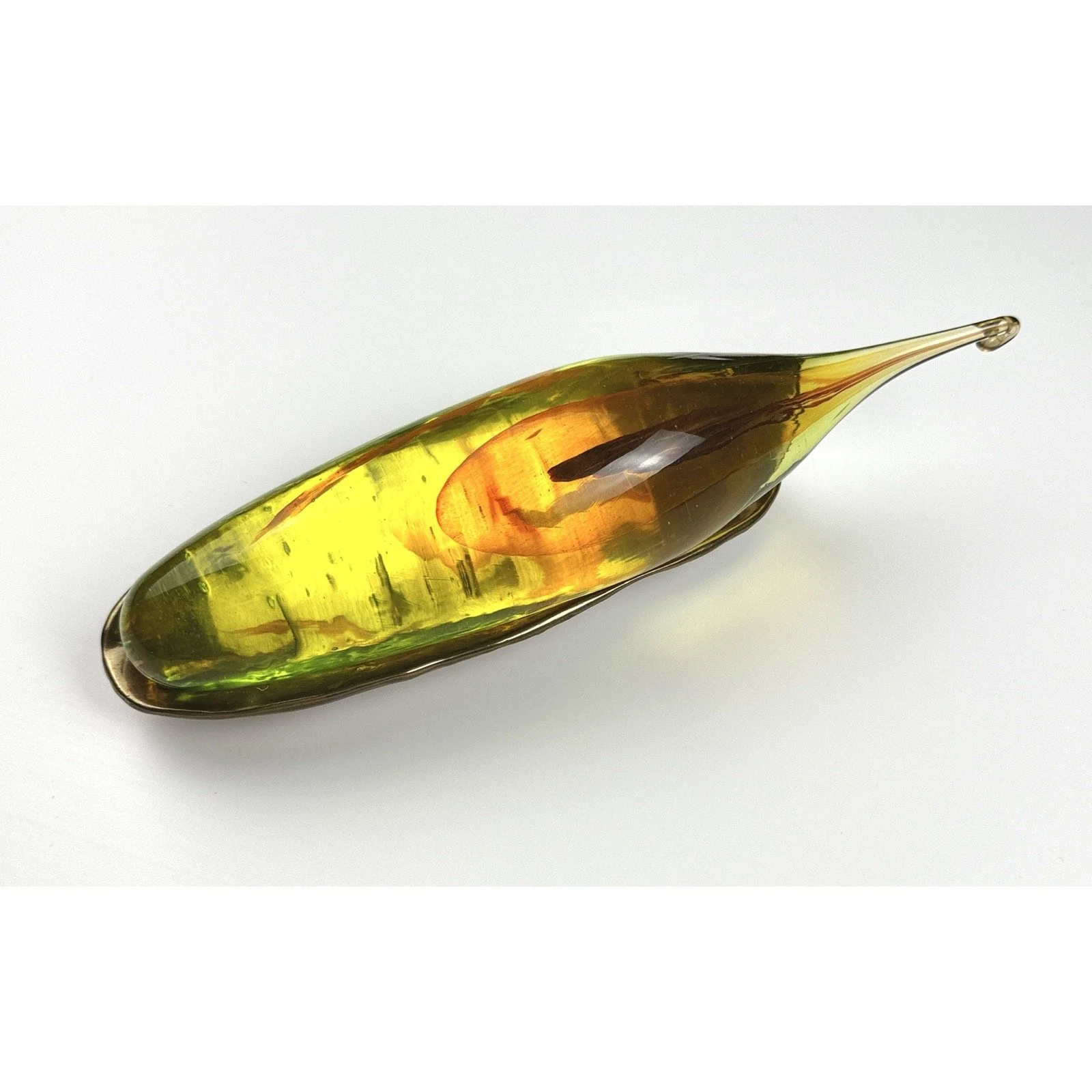 Overhead view of the amber, clear, yellow glass seed set on bronze cradle