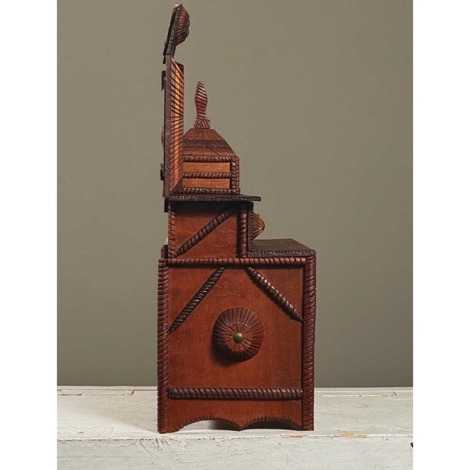 Side view highlighting carved knob ornamentation