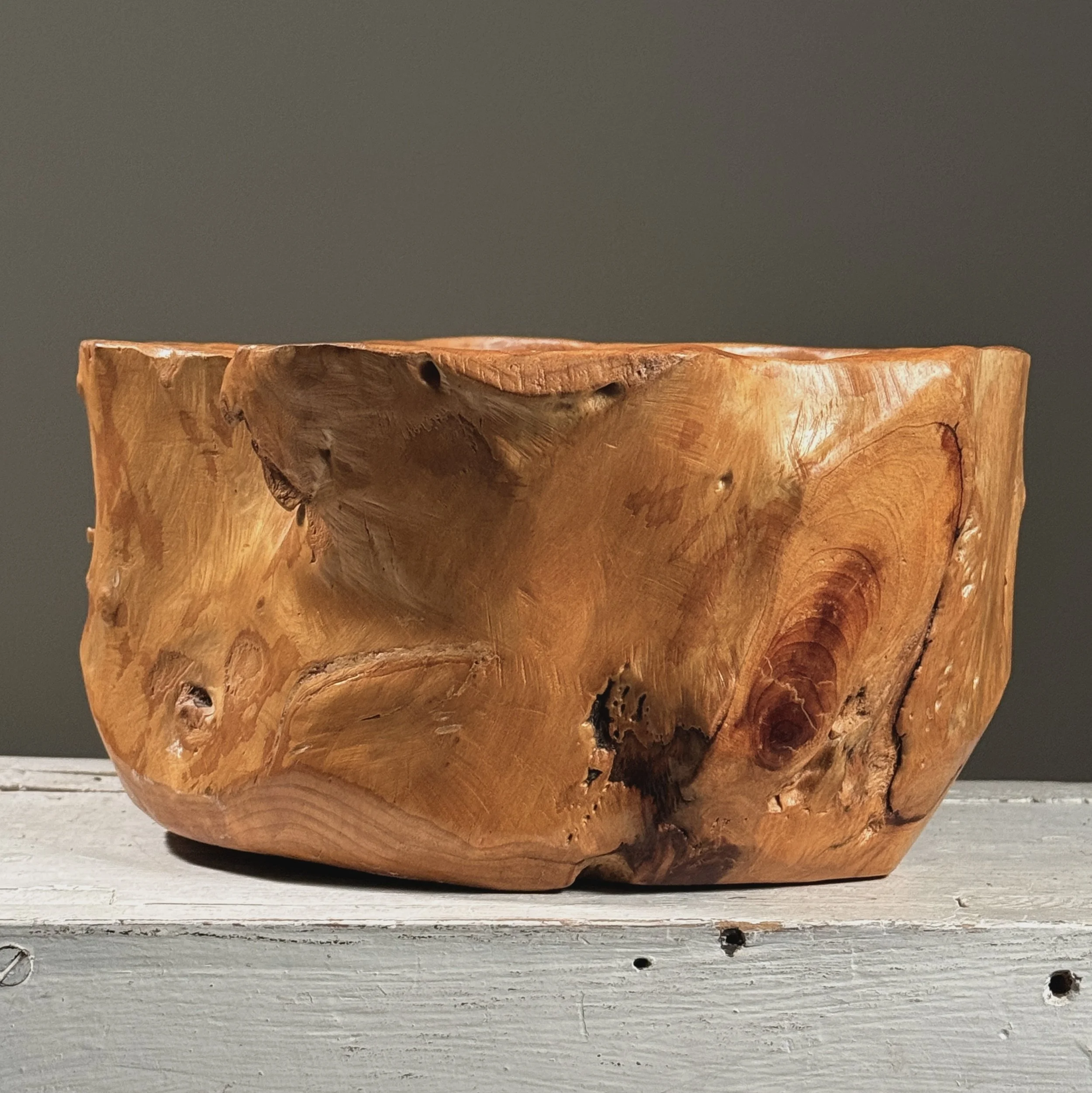 Full frontal view of a vintage hand-carved modernist root bowl with live edge exterior