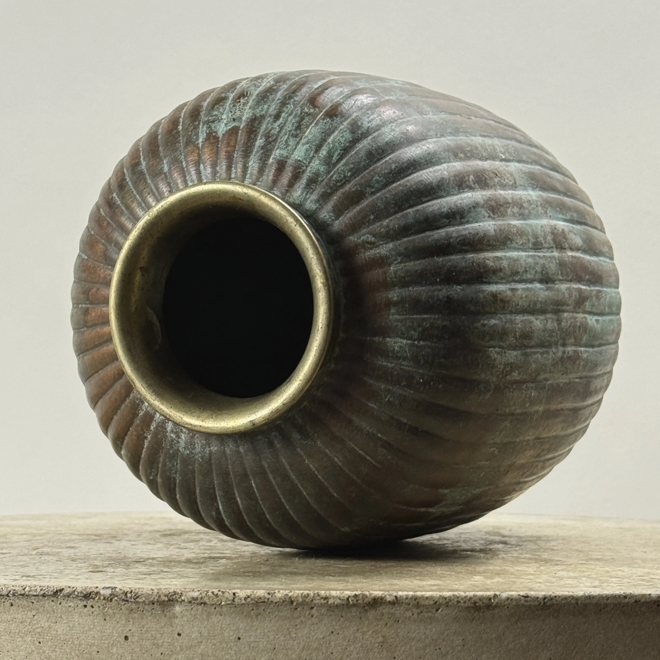View of vase rim and opening of antique Art Deco patinated brass ribbed vase