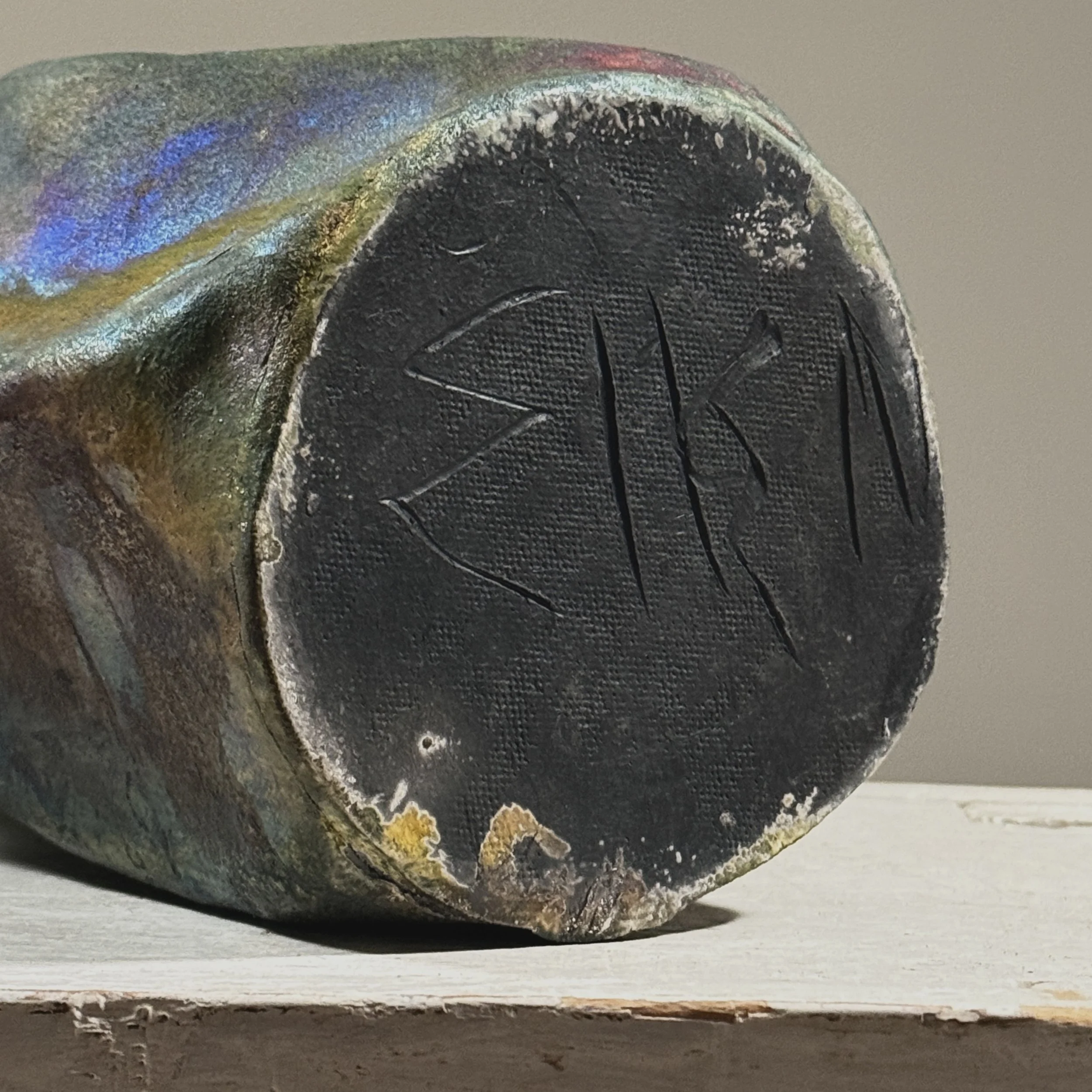 Signature detail, bottom of ceramic vessel, raku fired blackware