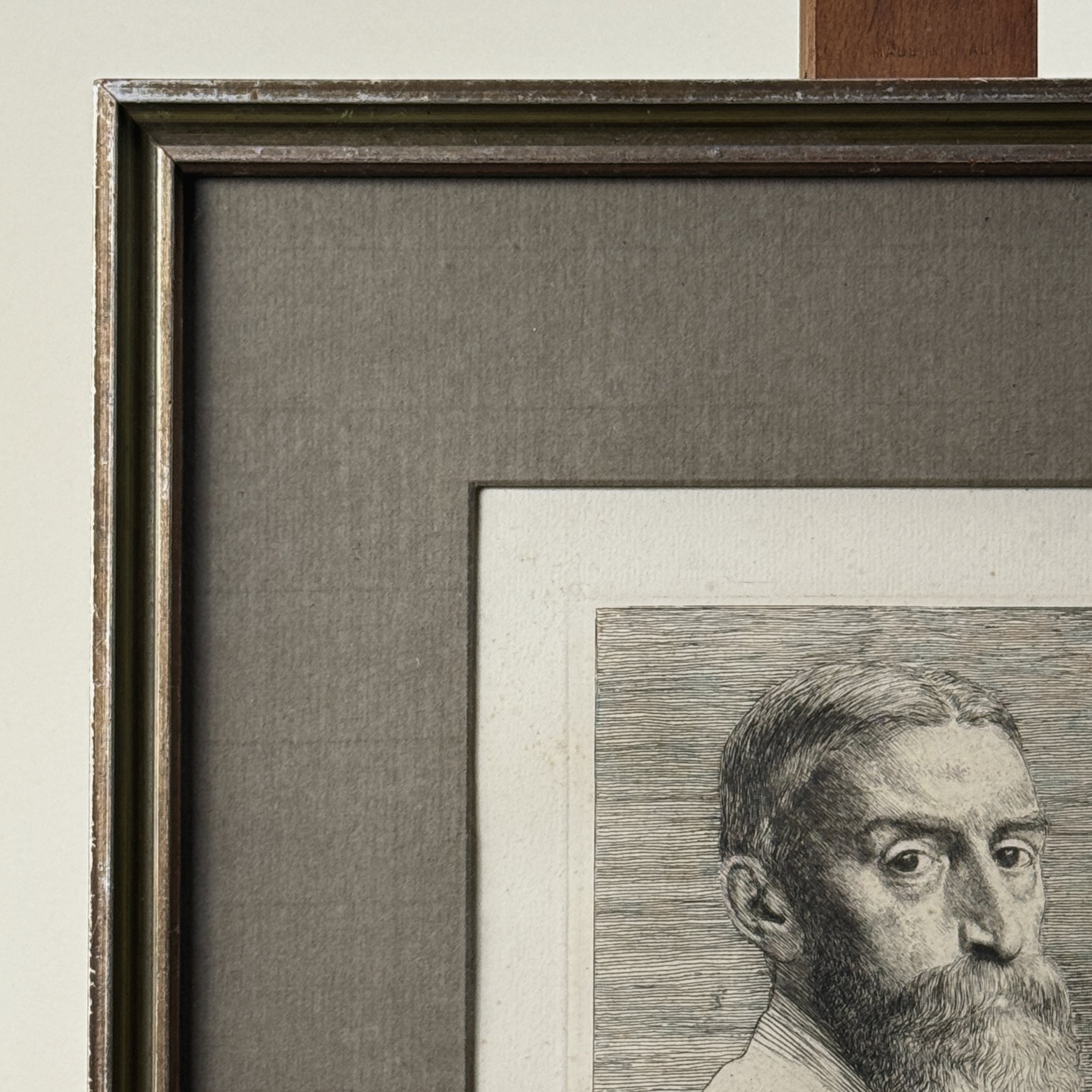 Frame detail. Patinated metal frame. Grey fabric mat.