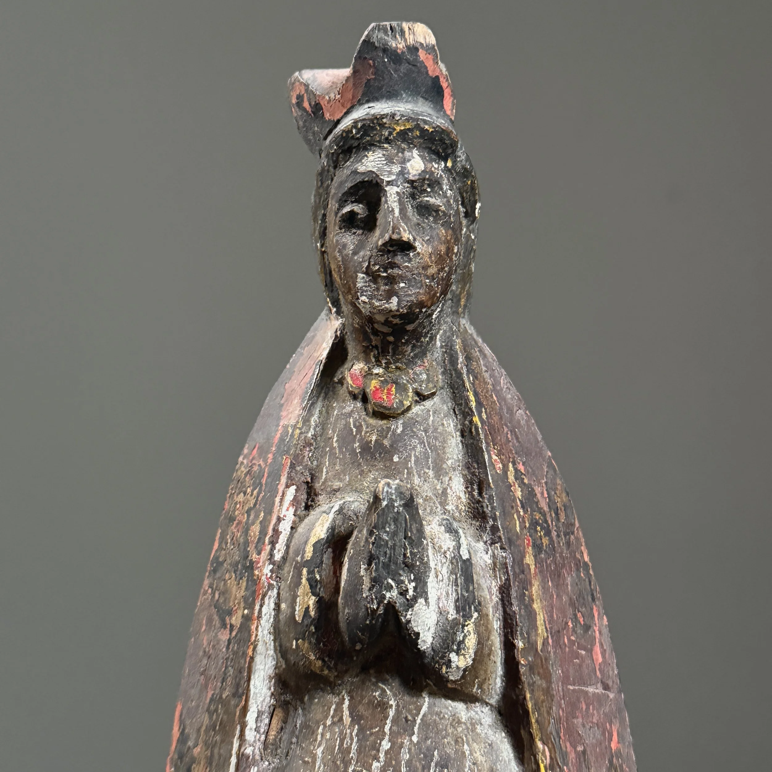 Close-up of the sculpture's surface, highlighting the crackled polychrome, patina, and exposed wood grain.