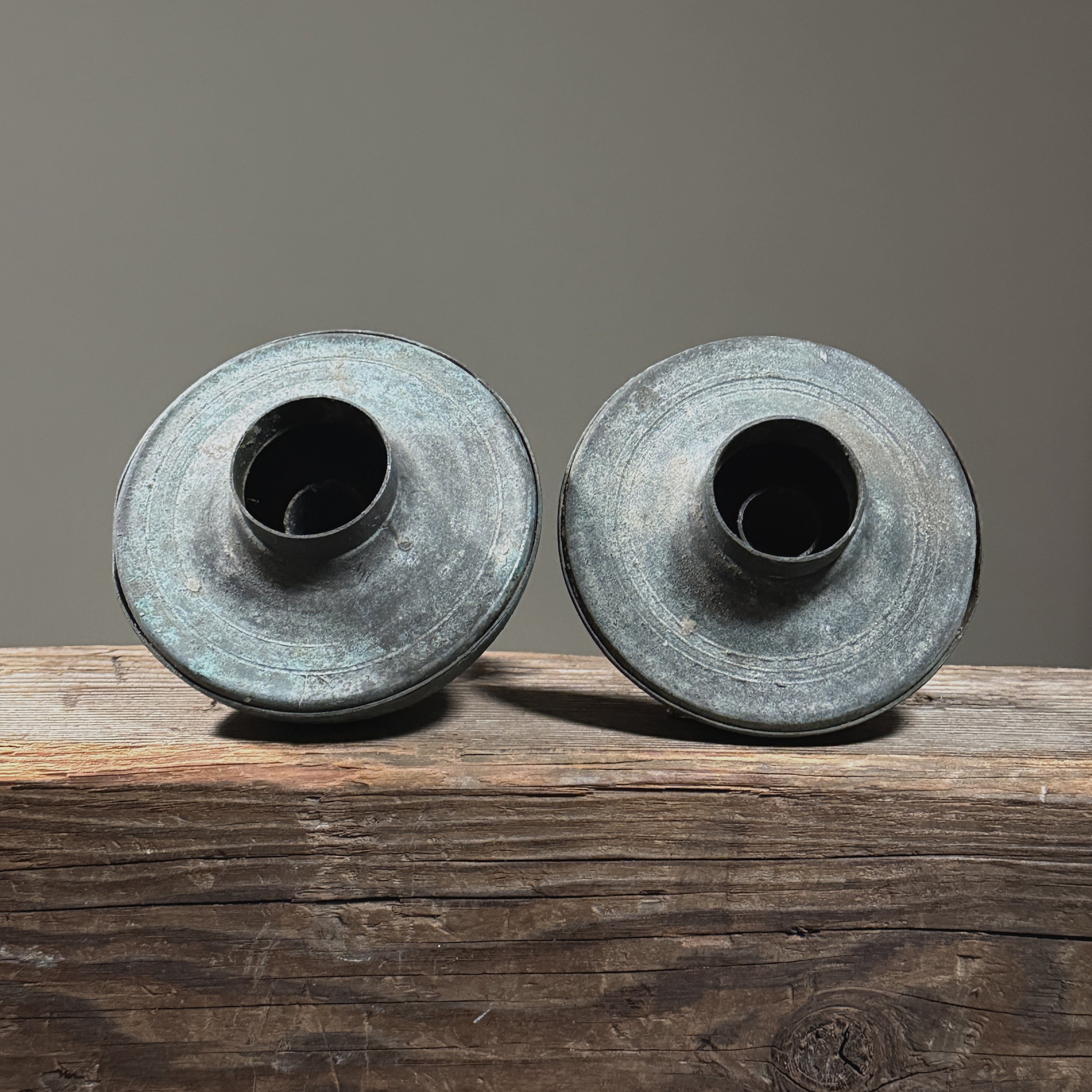 Top view of vintage Brutalist metal candle holder pair, verdigris patina, each 4.38 inches diameter by 3.25 inches height.