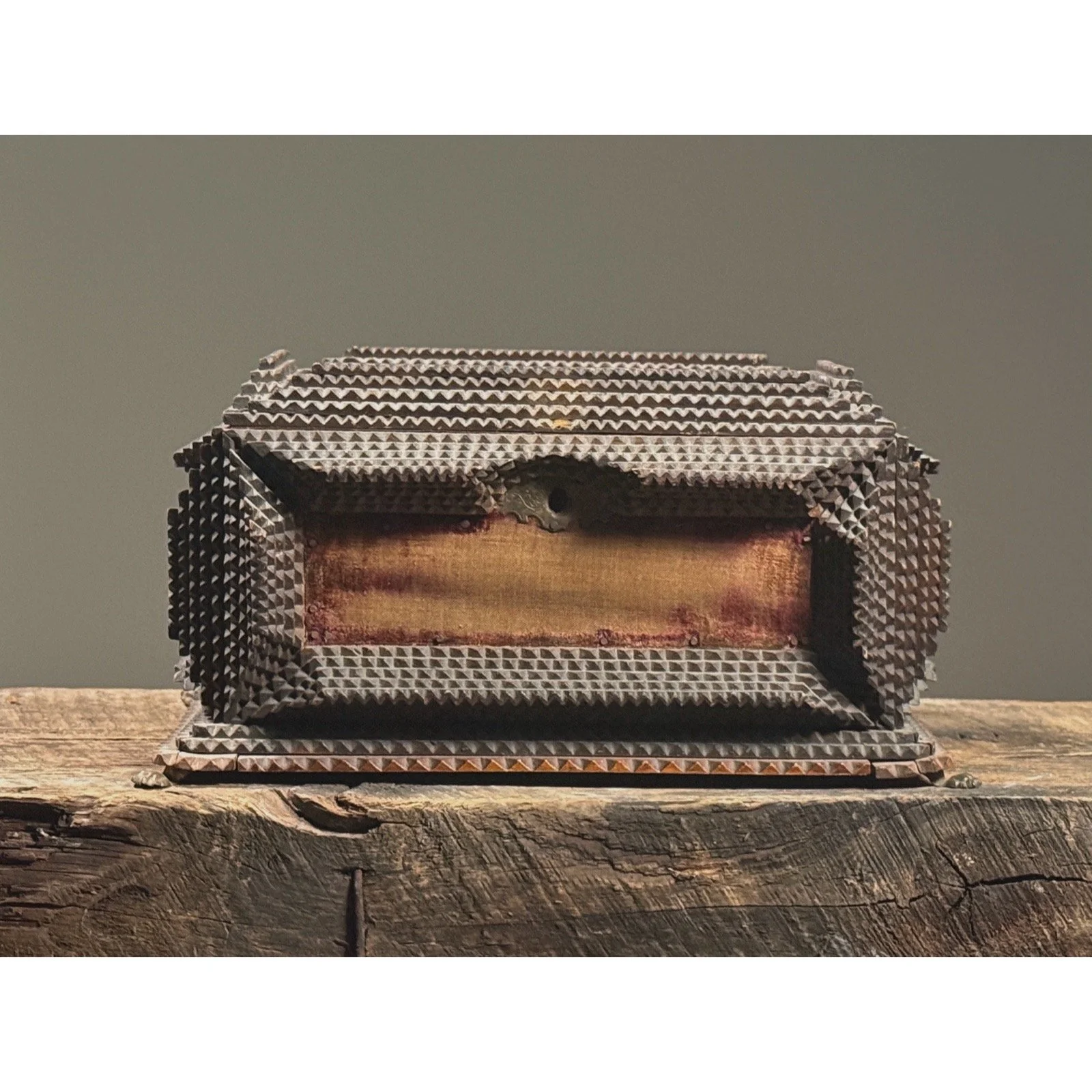 Front view of an antique tramp art box with purple velvet panels.