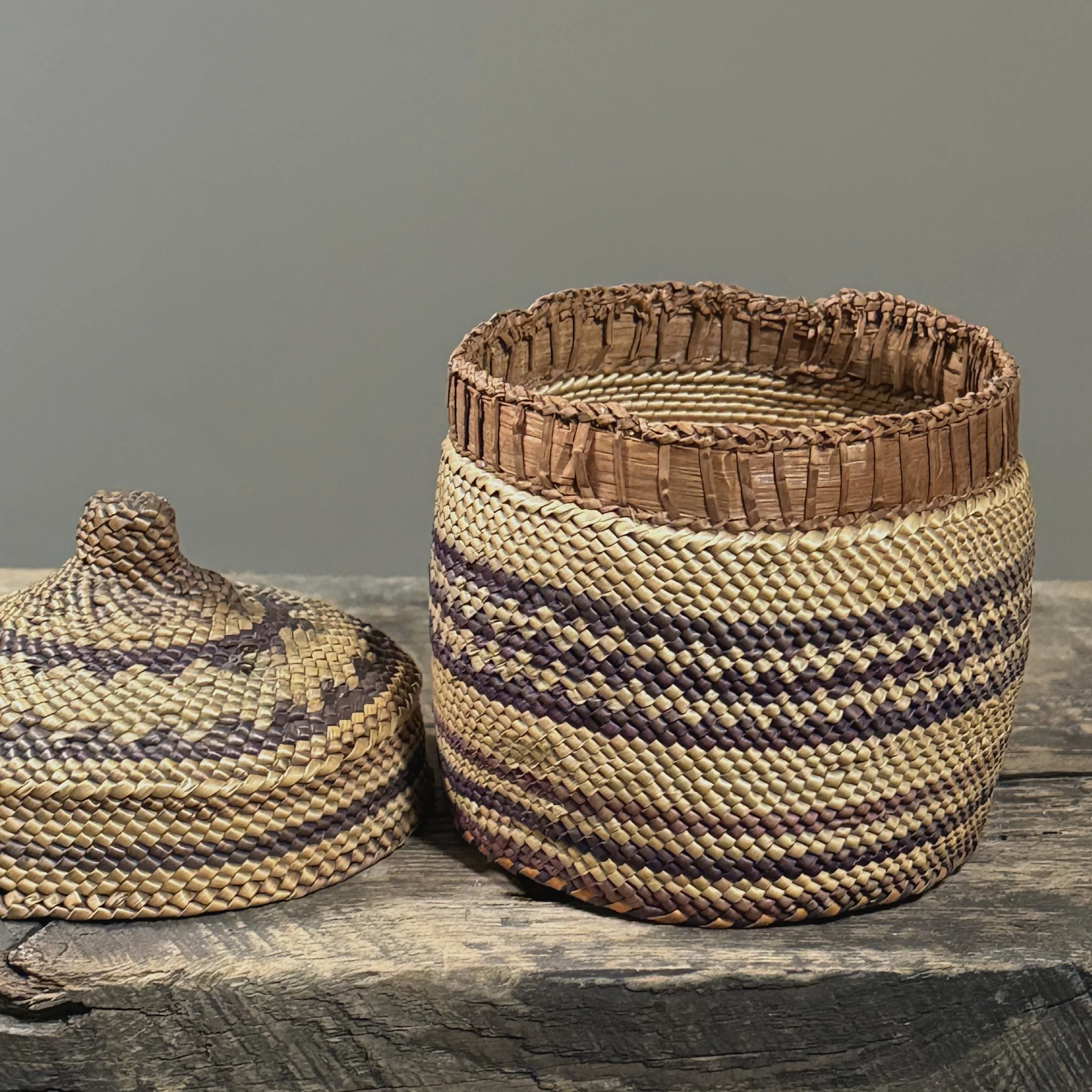 Close-up detail of wrapped twining technique and purple-dyed grass on an antique Makah basket