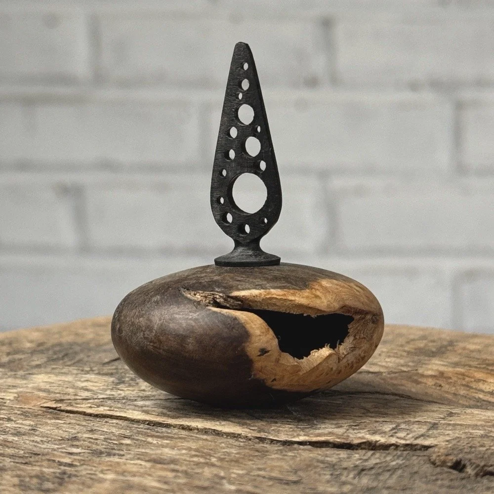 Vintage miniature turned burl wood vessel with hand-carved ebony topper on white background