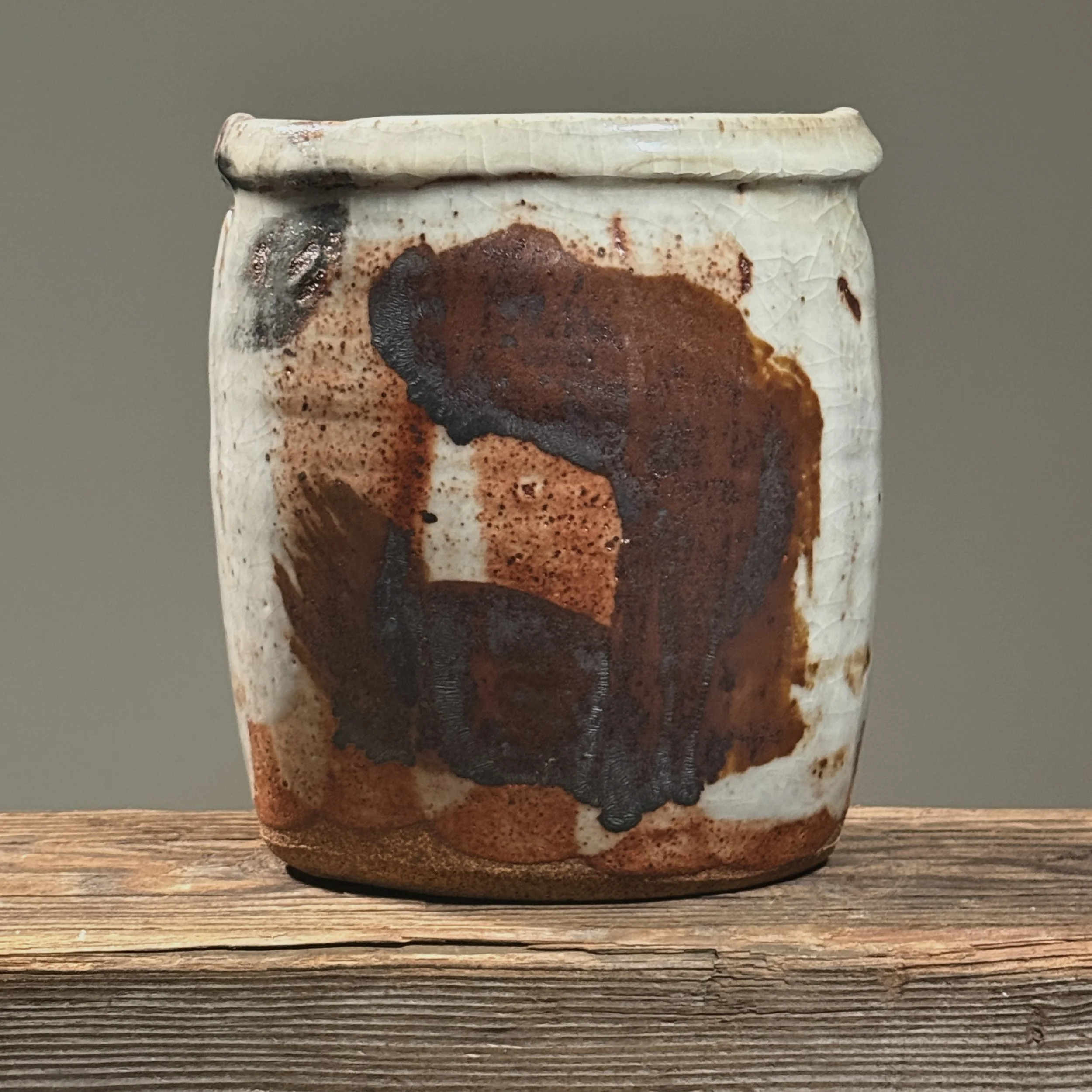 Vintage Japanese Raku fired ceramic vessel on white background. Shino crackle glaze visible.