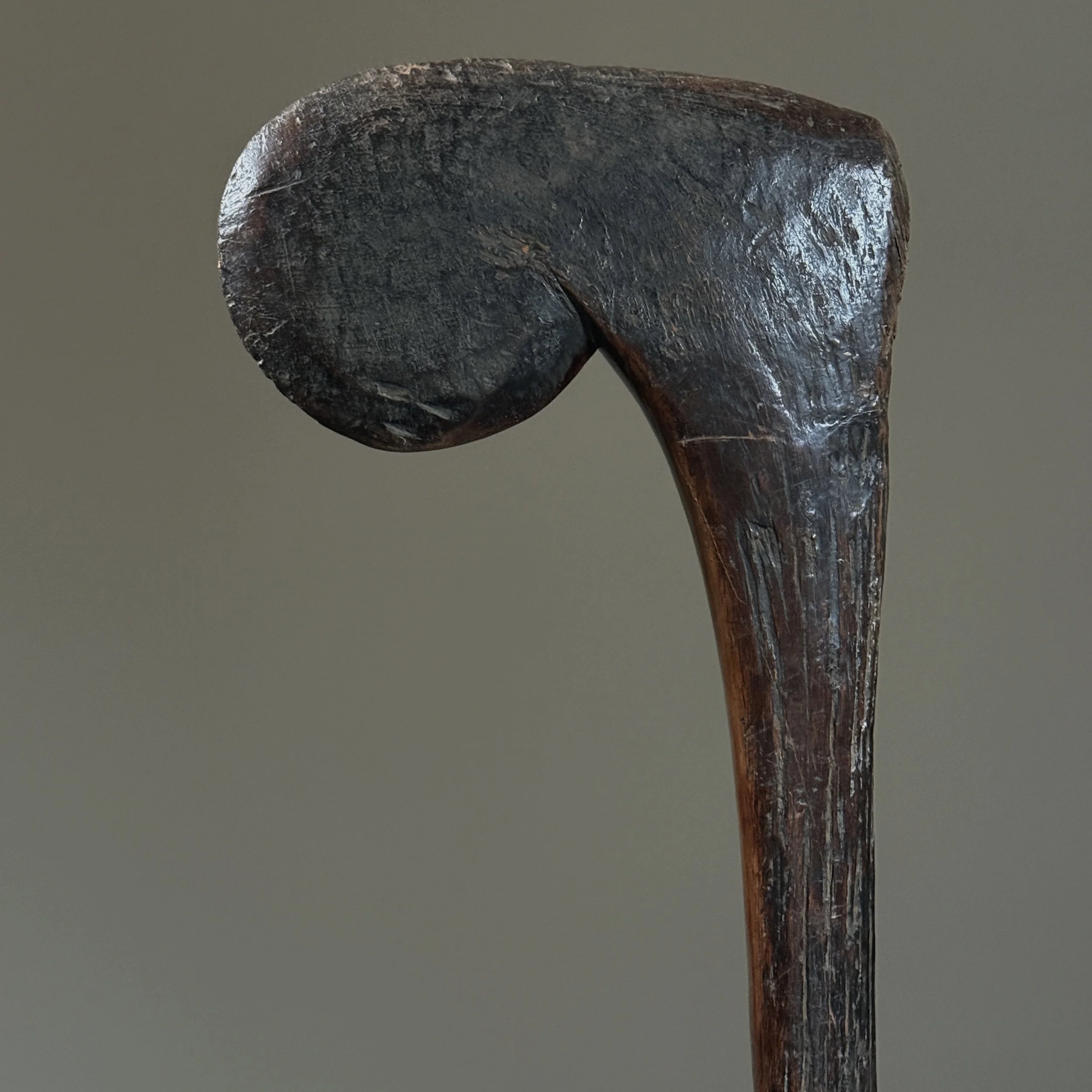 Detail of the abstracted figurative finial of a Bobo wood scepter, showing a dark, patinated surface.
