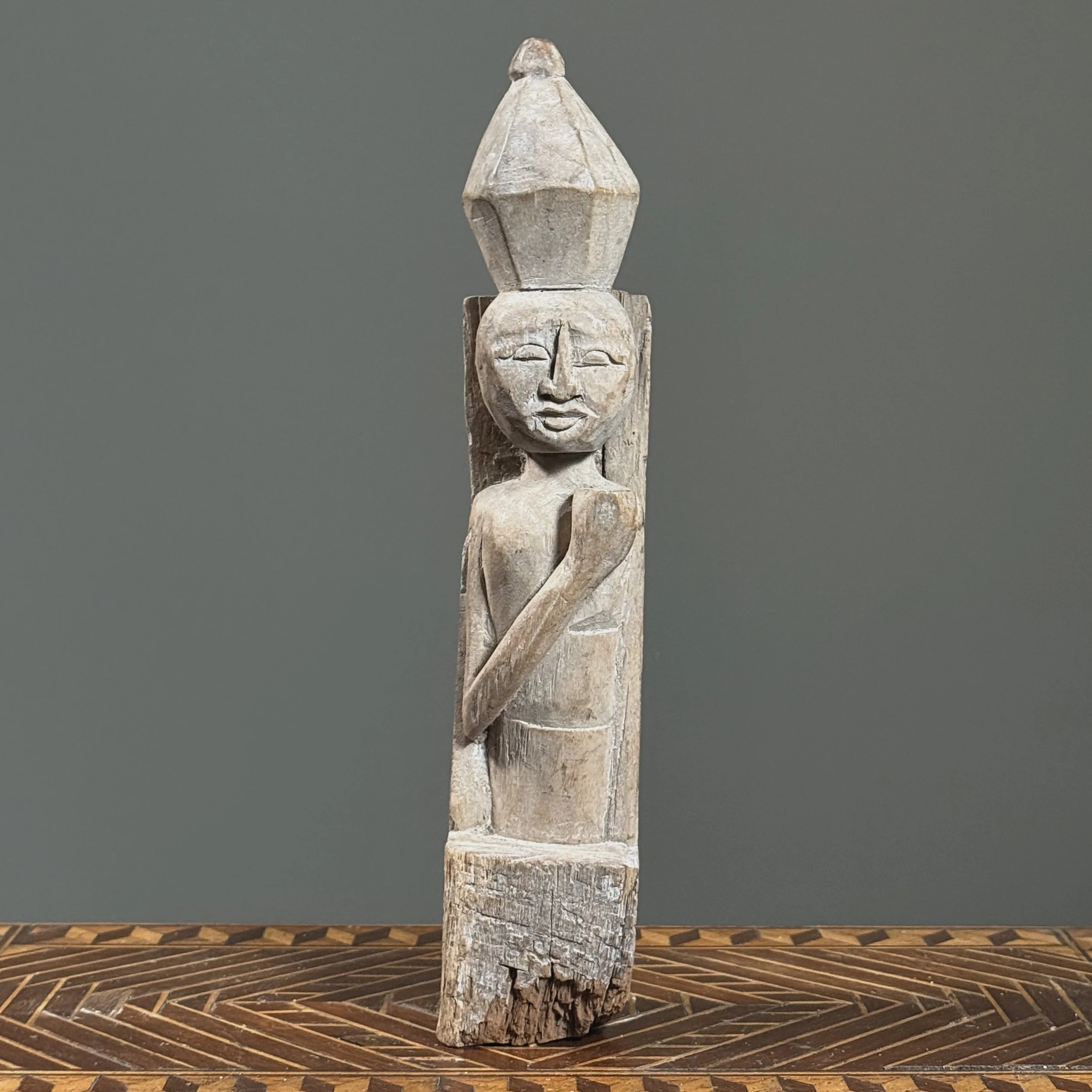 Whitewashed Indonesian wooden figure finial, front view.