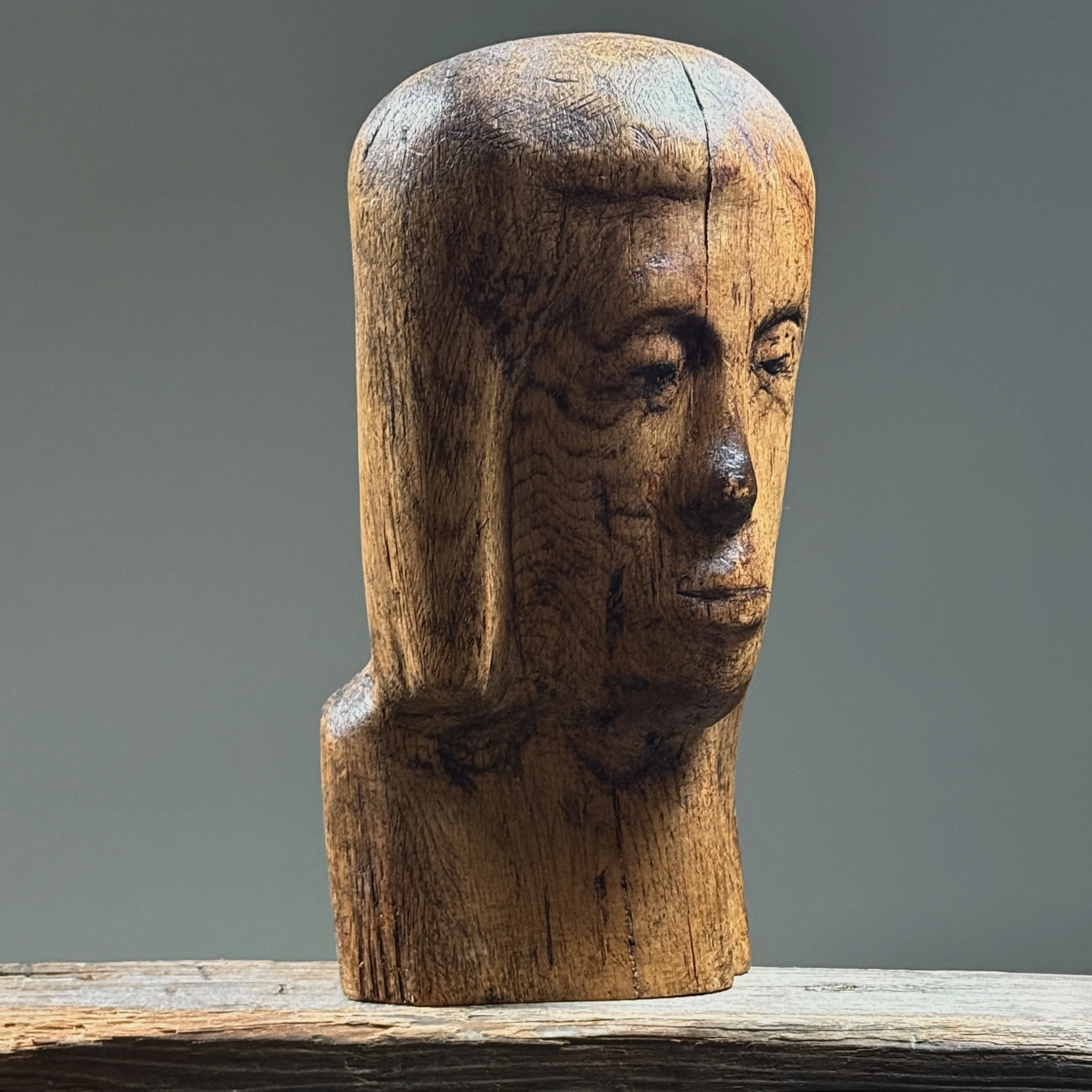 Three-quarter view of hand carved wood portrait bust in Folk Art Modernist style, vintage, deep patina