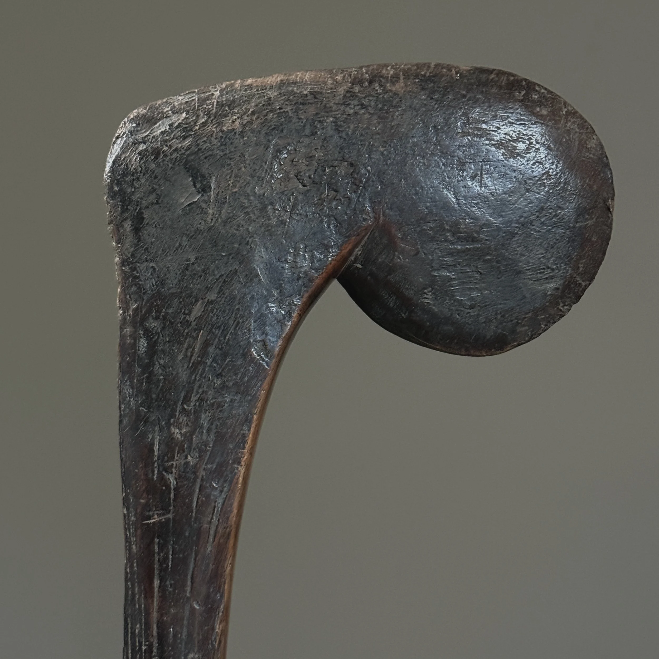 Detail of the abstracted figurative finial of a Bobo wood scepter, showing a dark, patinated surface.