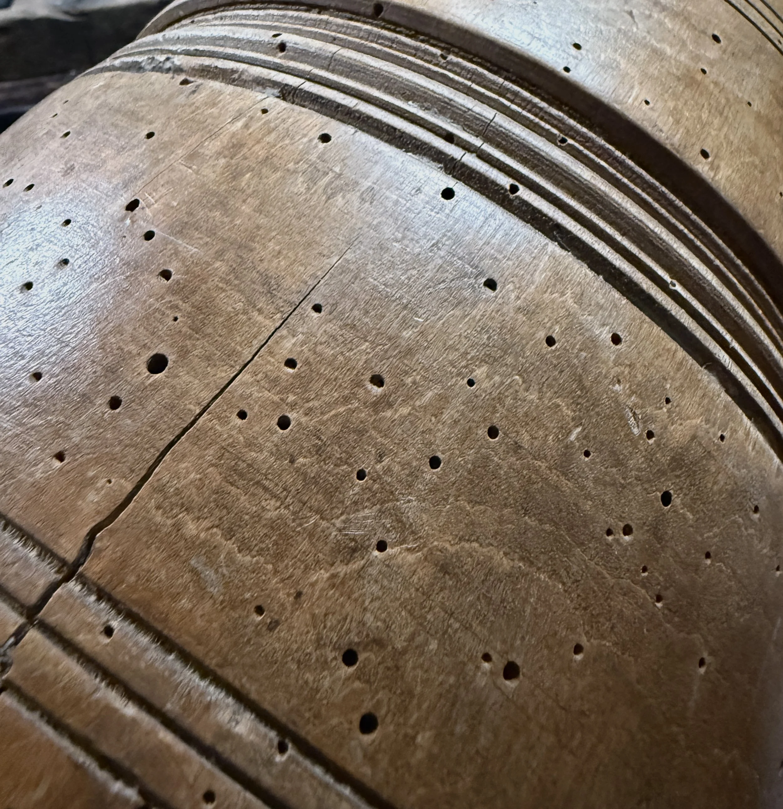 Front view of antique treenware barrel with concentric ribbed bands