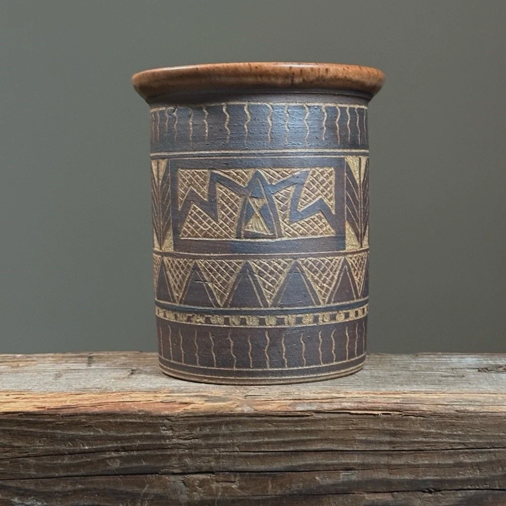 Full frontal view of a vintage sgraffito ceramic vase with geometric folk art design.