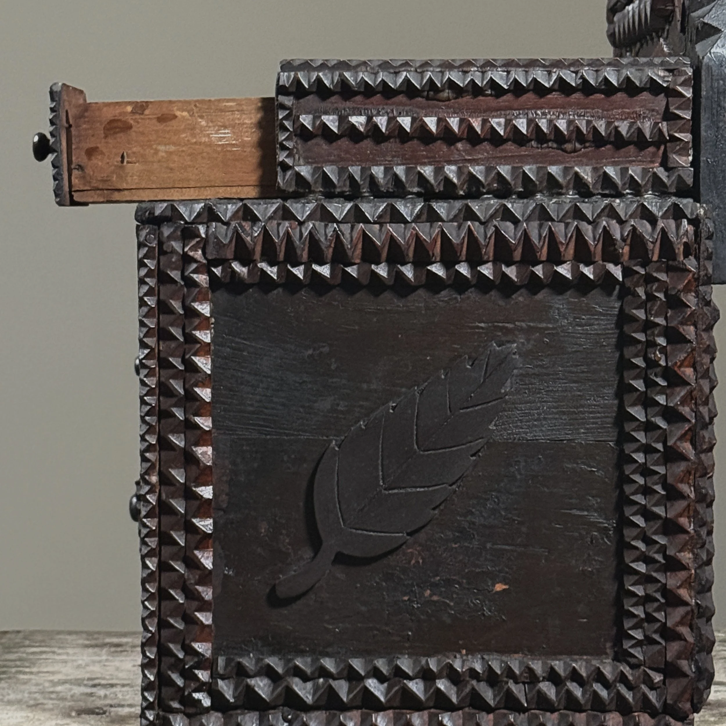Side view showing the applied chip-carved leaf motif.