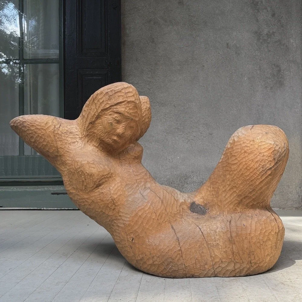 Full frontal view of a vintage monumental modernist wood sculpture of a reclining woman