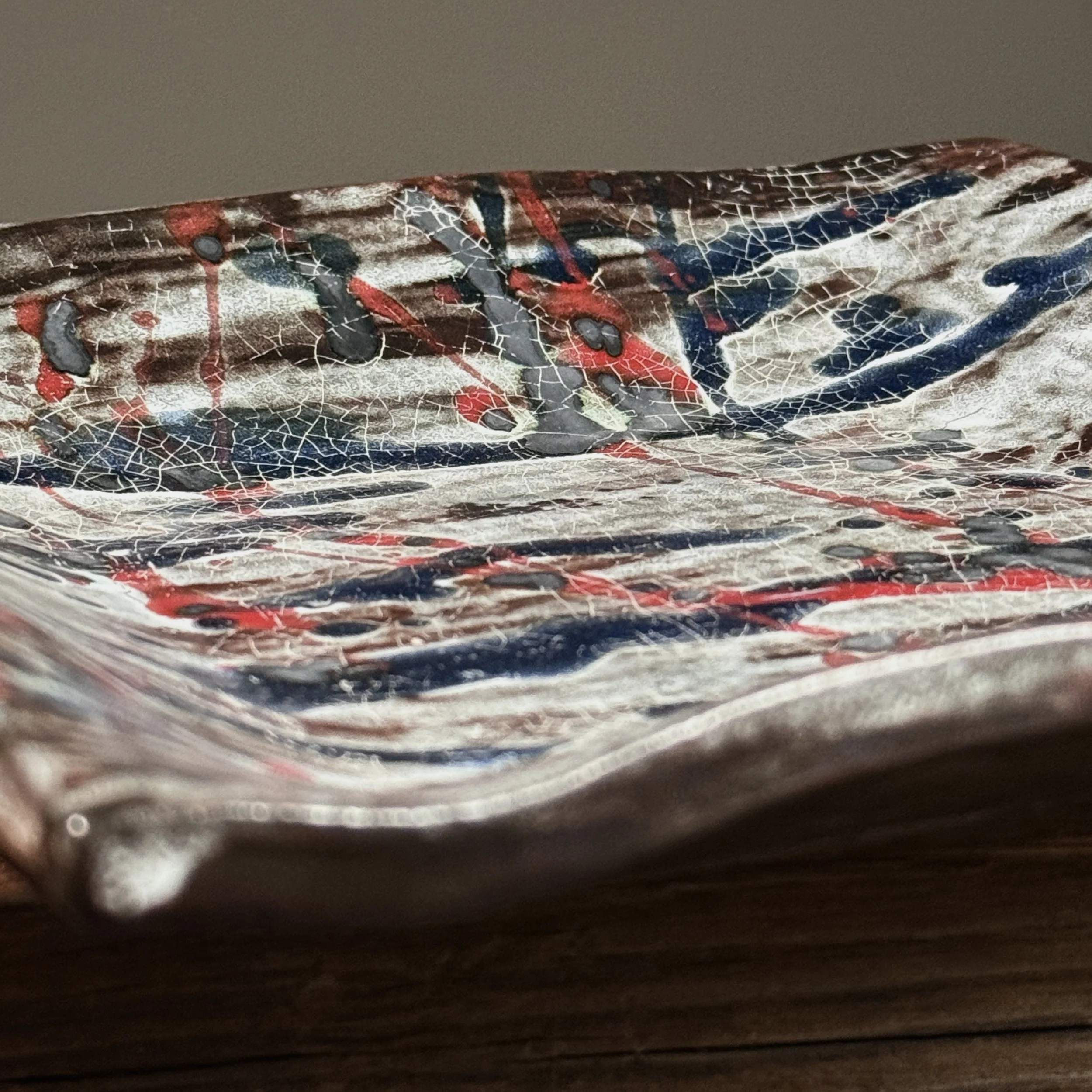 Detail of splatter glaze. Abstract Expressionist gesture. Blue and red pigment application.
