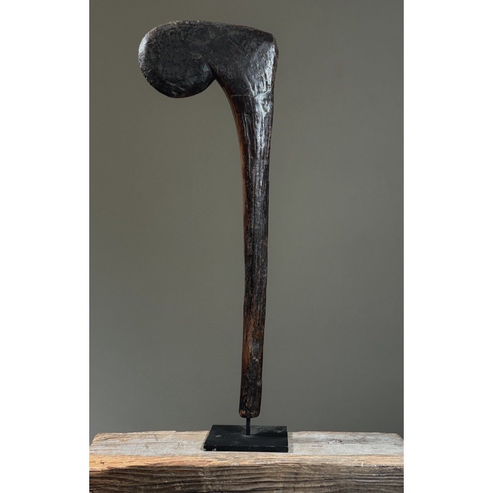 A hand-carved wooden ceremonial scepter from Burkina Faso, Bobo-style, on a black metal stand.