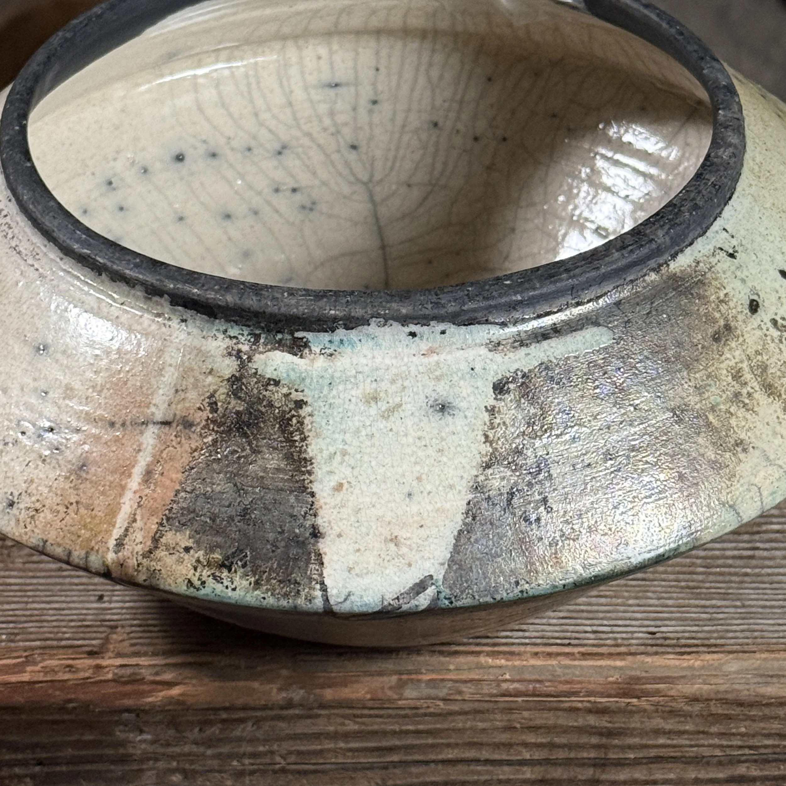 Close-up of ash marks. Raku firing effects. Ash settled on glaze surface.