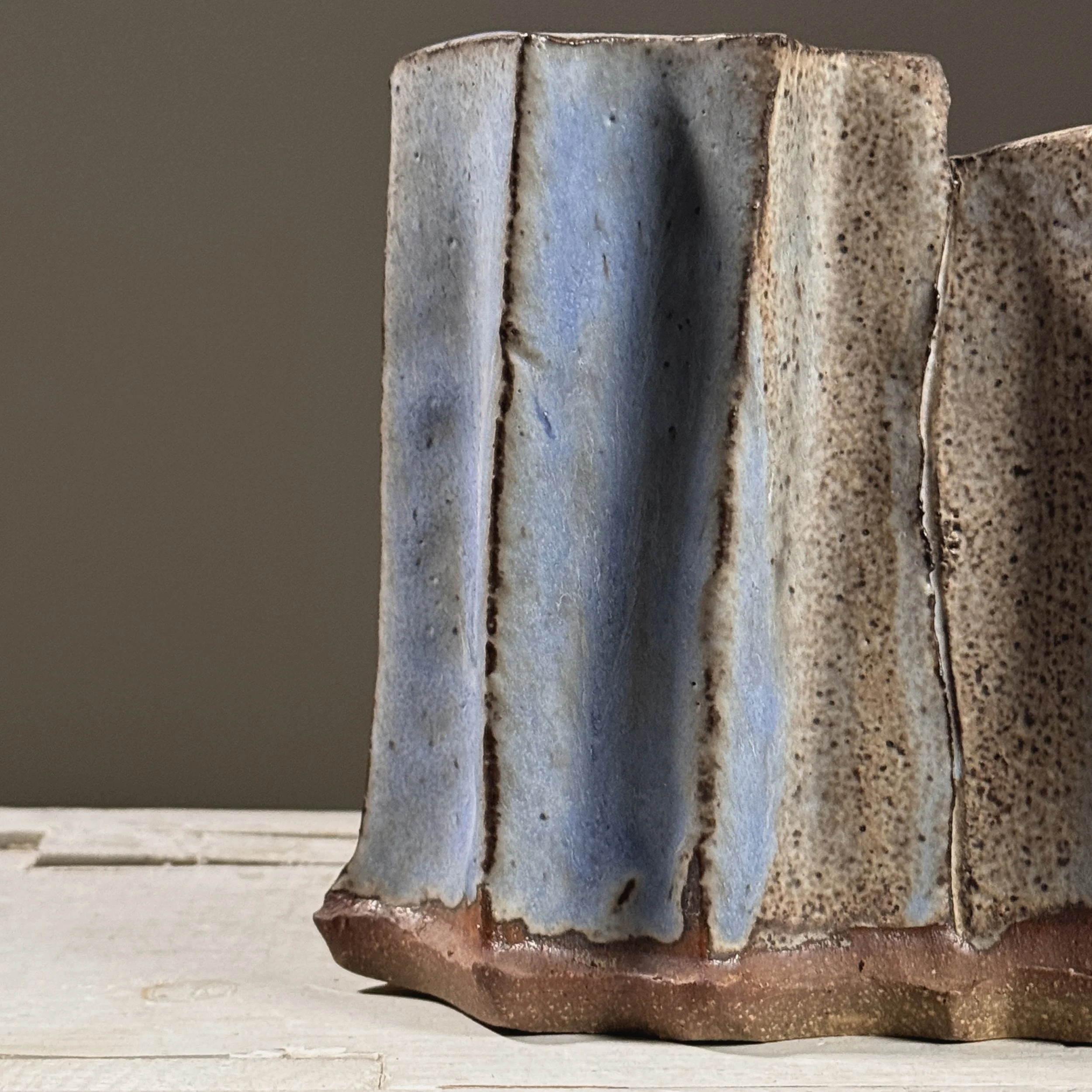 Detail of grey speckled glaze surface with blue accents.