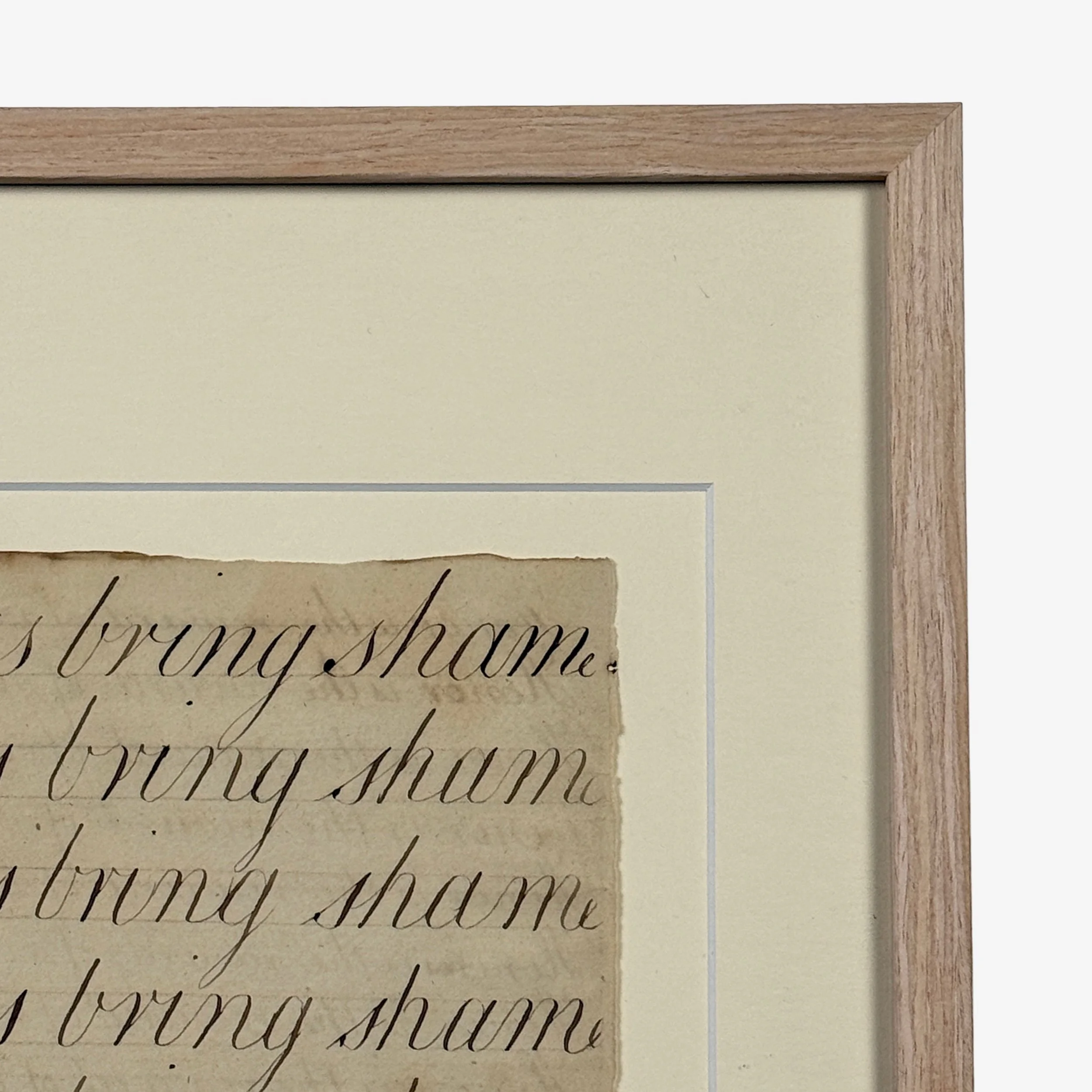 Framed antique calligraphy under glass in blond wood frame