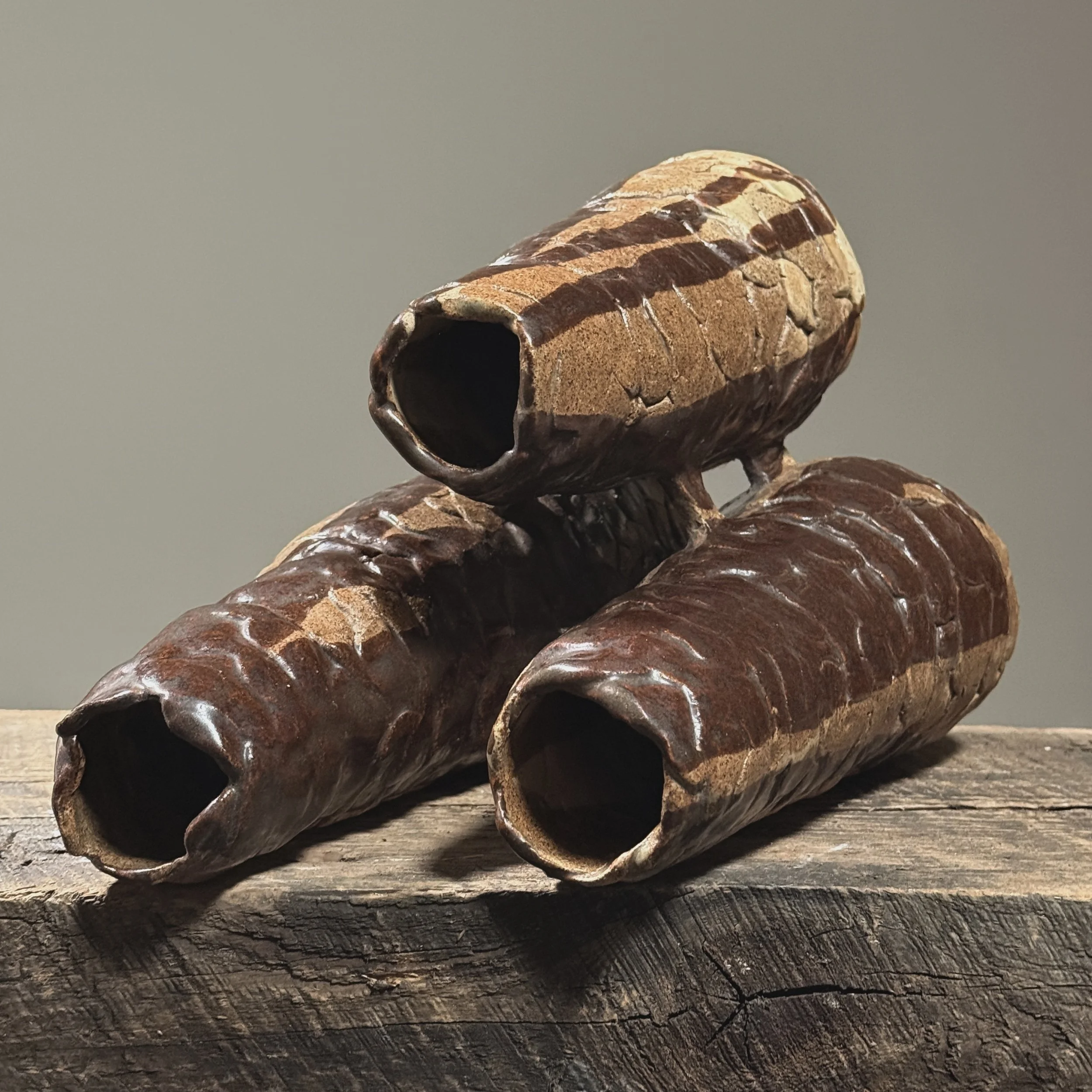 Elevated view looking down onto three conjoined cylinders of a hand-built Brutalist vessel