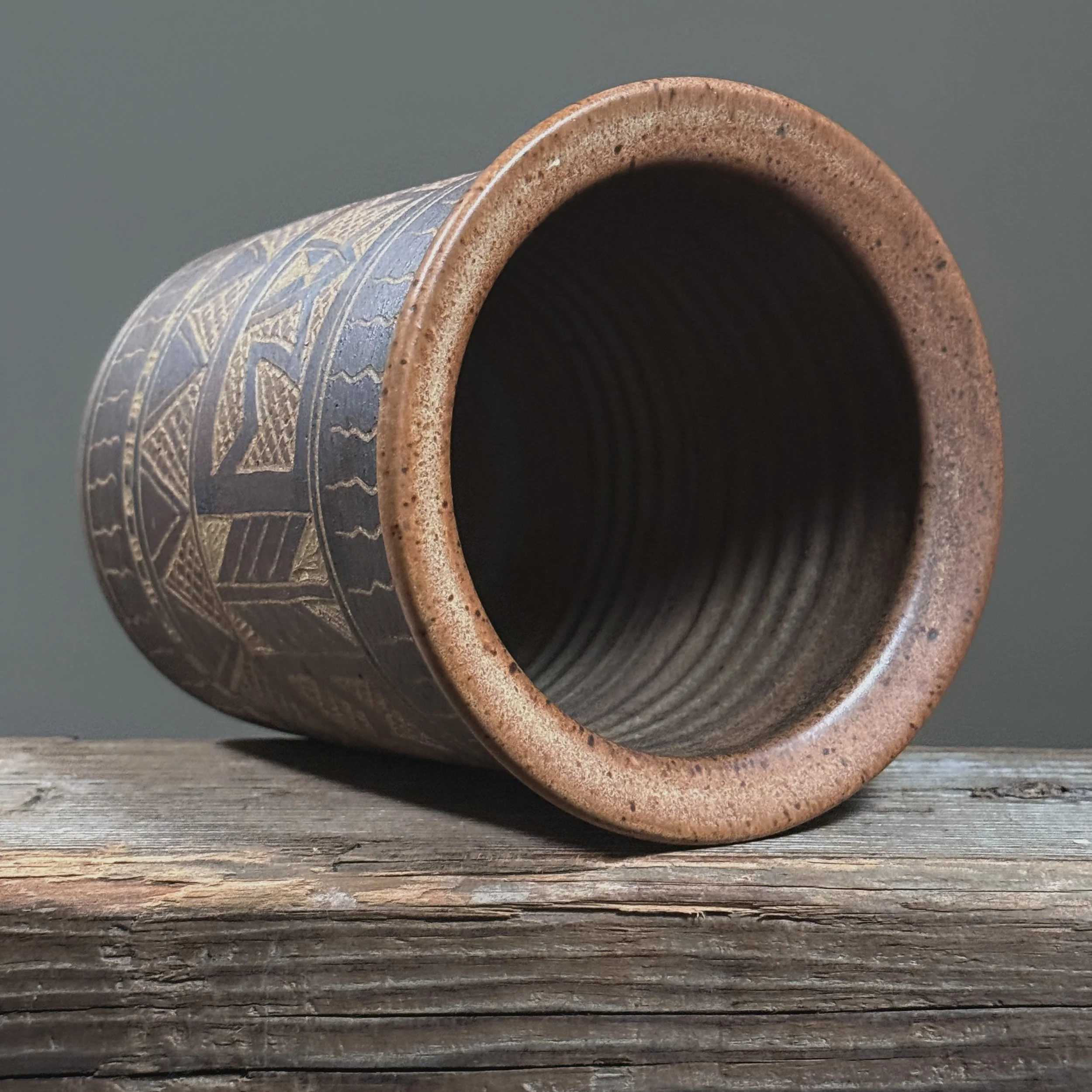 Elevated view looking into the opening of a vintage geometric folk art ceramic vase.