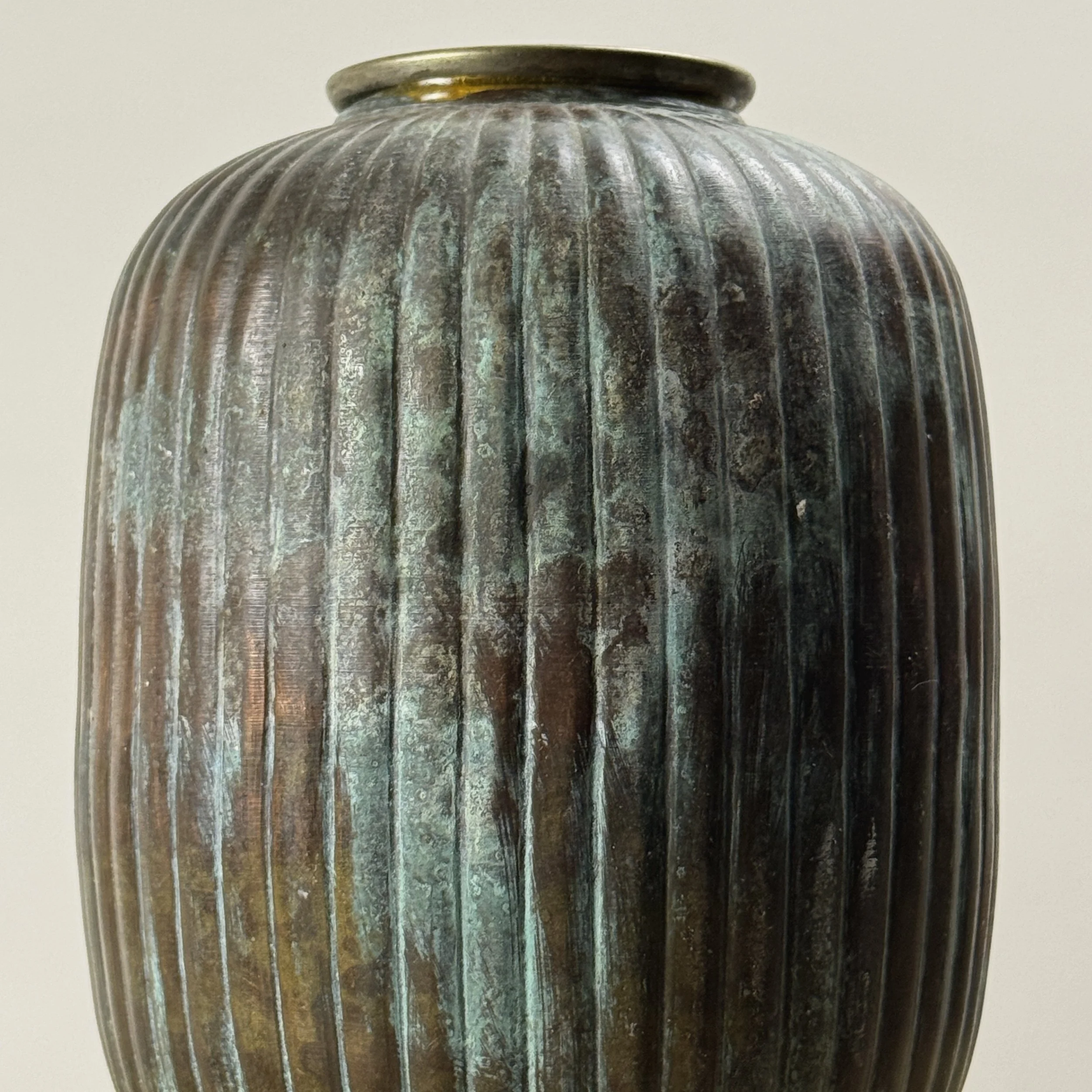 Detail view of verdegris patination on greyish-brown brass vase, Art Deco style, antique