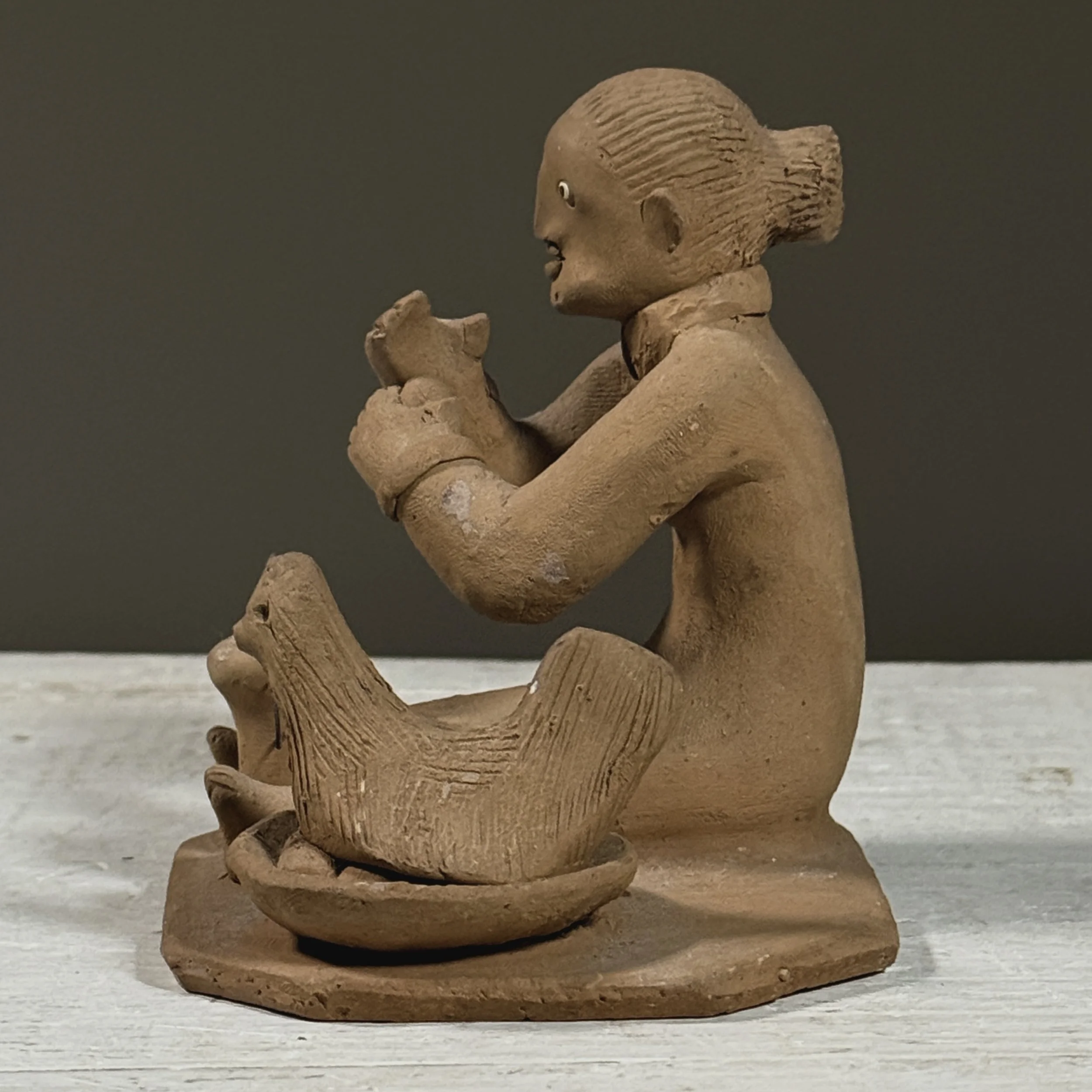 Profile view showing the sculpture's depth and the compactness of the forms.