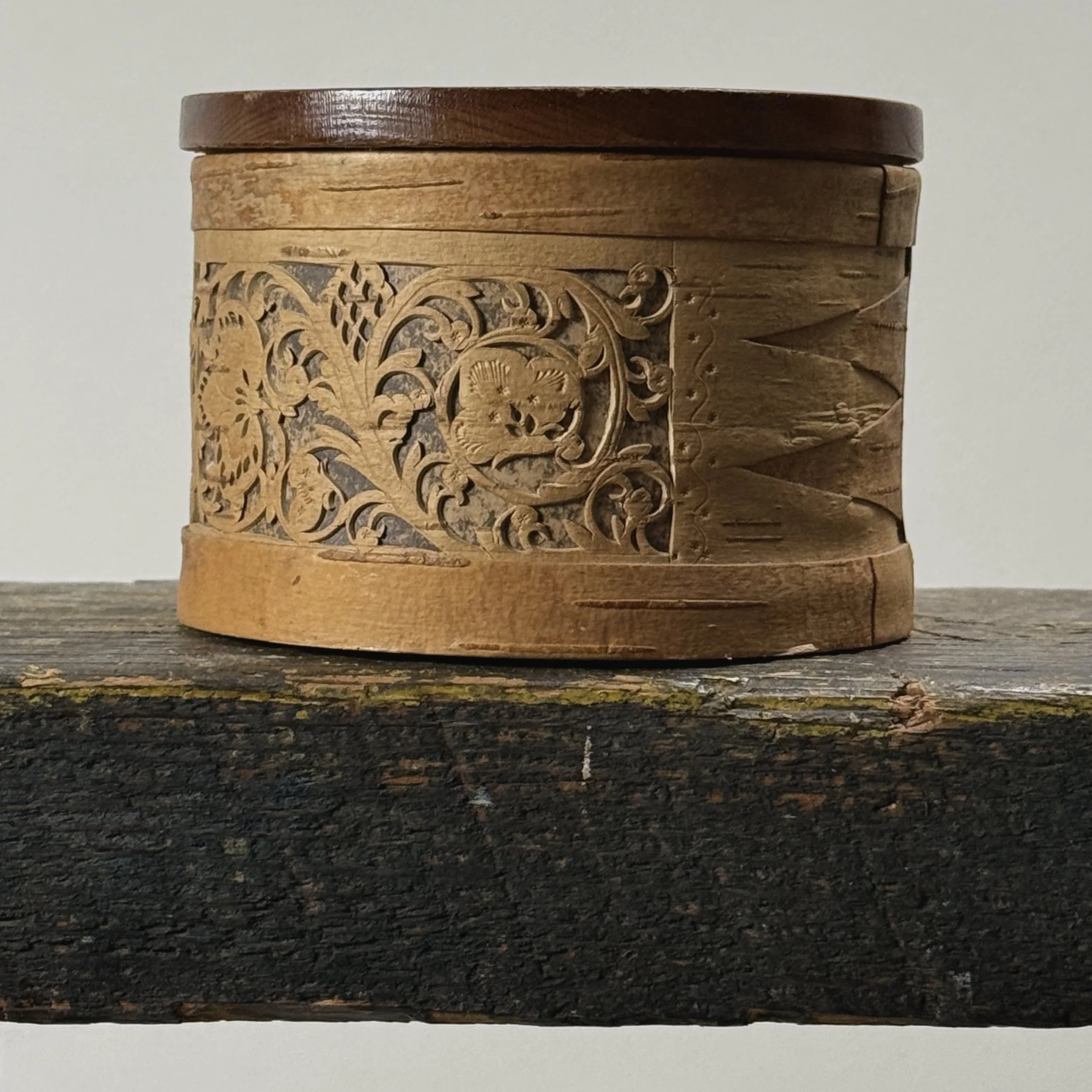 Side view of box exterior with repeating bird and leaf patterns