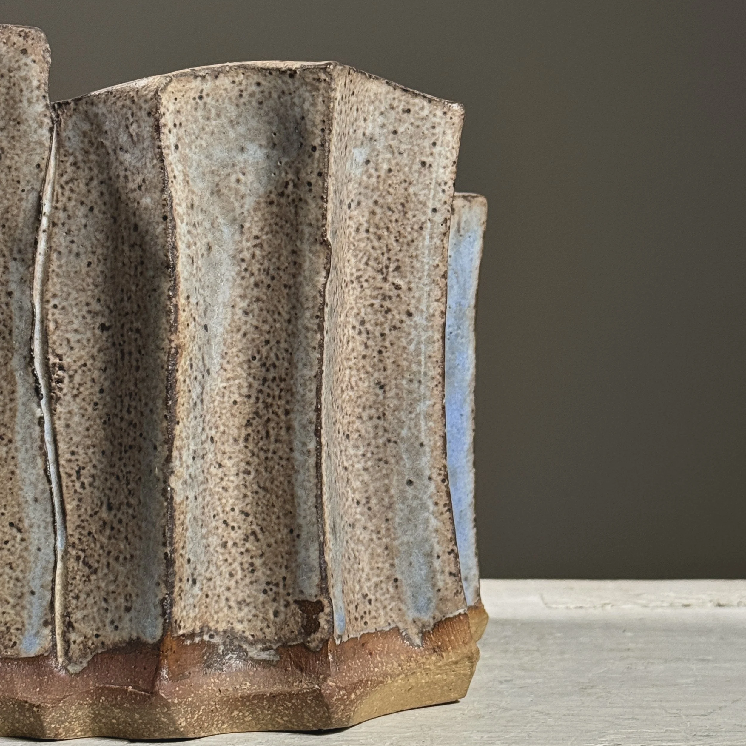 Detail of grey speckled glaze surface with blue accents.