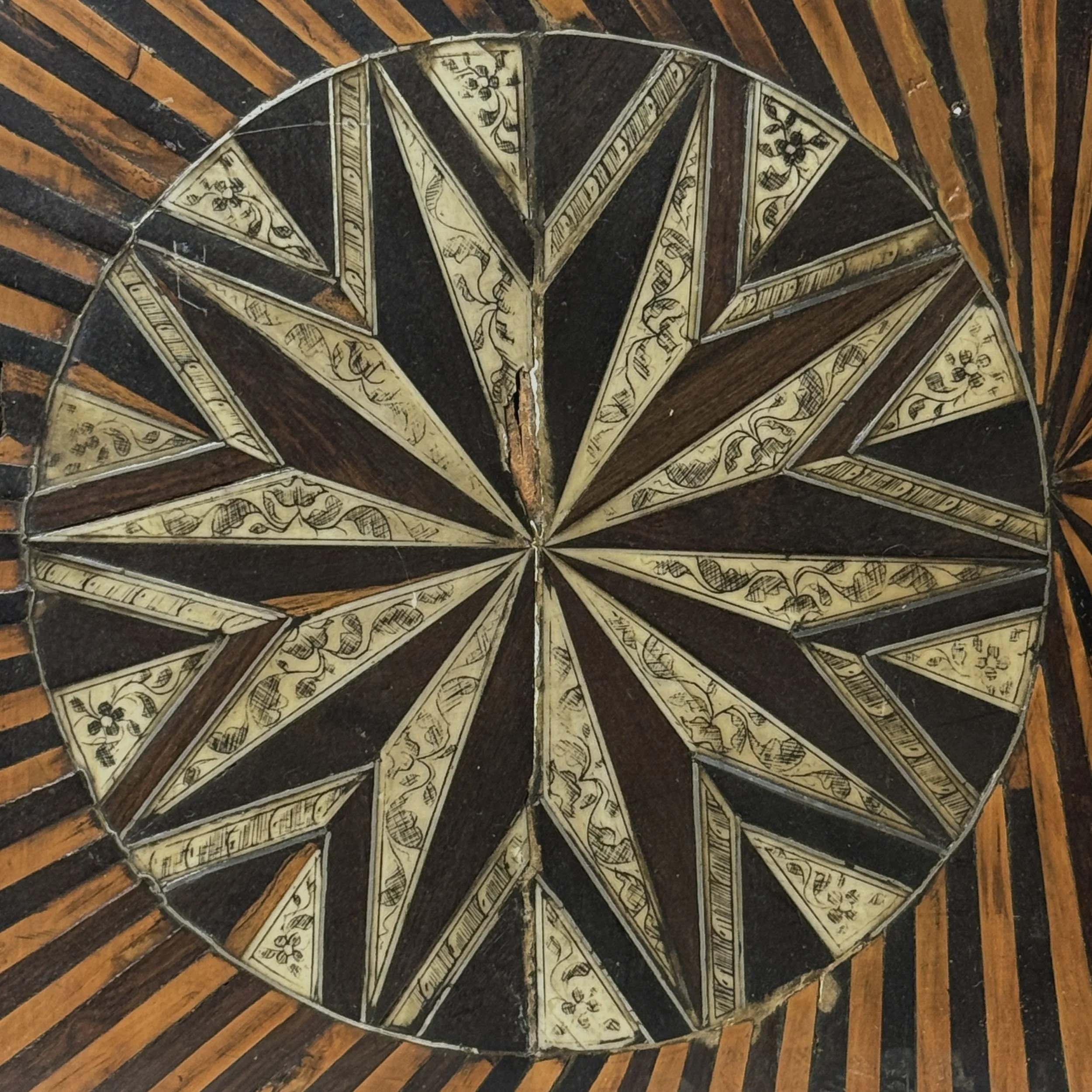 Front view of cabinet doors. Two-tone sunburst parquetry. Hand carved wood.