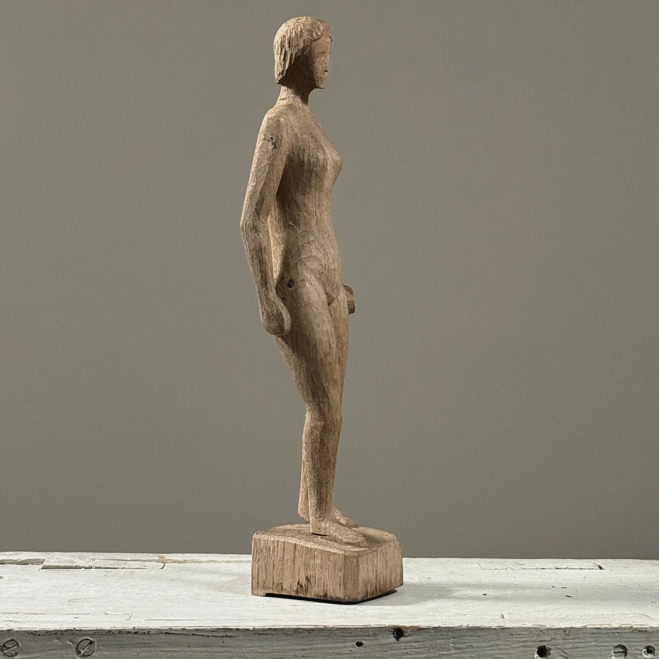 Profile view of vintage hand carved wood modernist female nude sculpture, raw wood, small integral base