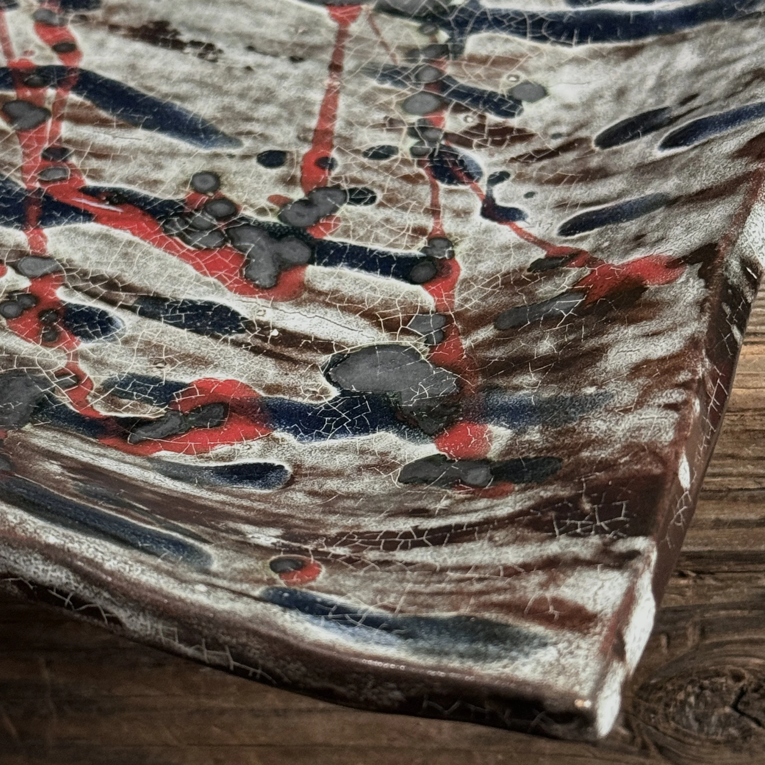 Detail of splatter glaze. Abstract Expressionist gesture. Blue and red pigment application.