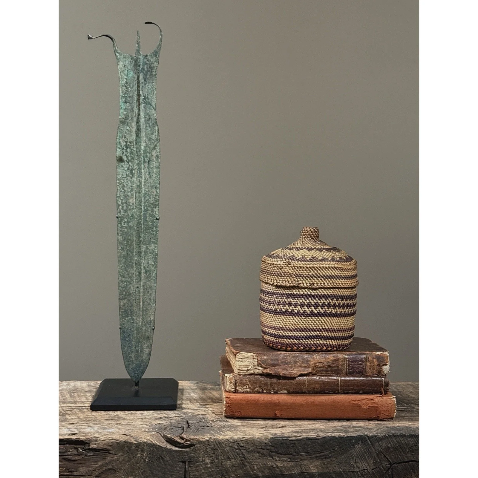 Full frontal view of an antique Makah woven lidded basket with purple geometric decoration