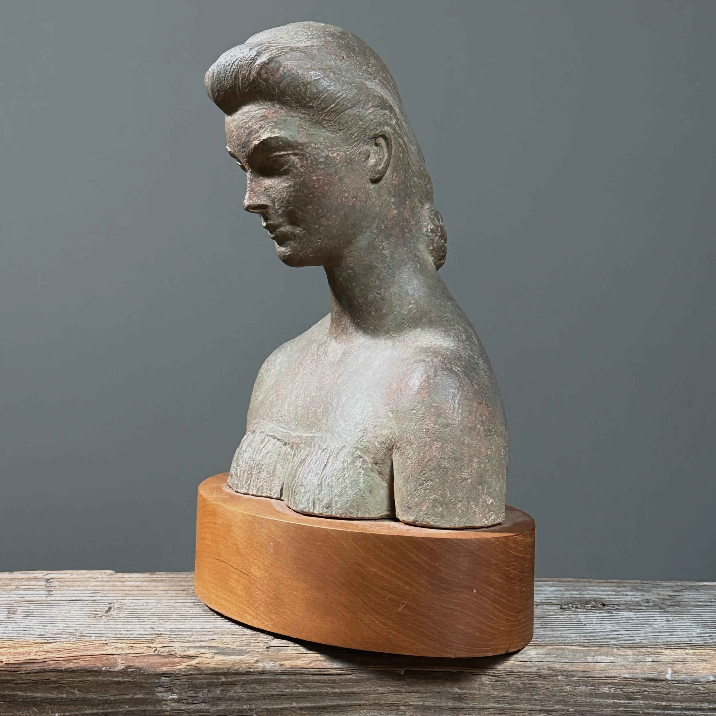 Three-quarter view of Solowey plaster portrait bust with mottled greyish-green surface