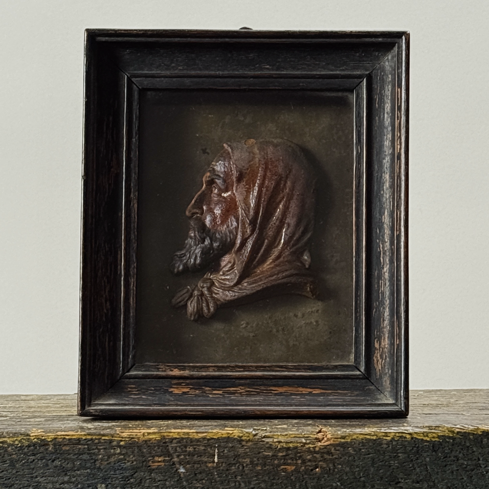 Full front view of antique French red wax bas-relief profile of bearded man with hood, housed under glass in black wood frame, signed and dated 1761