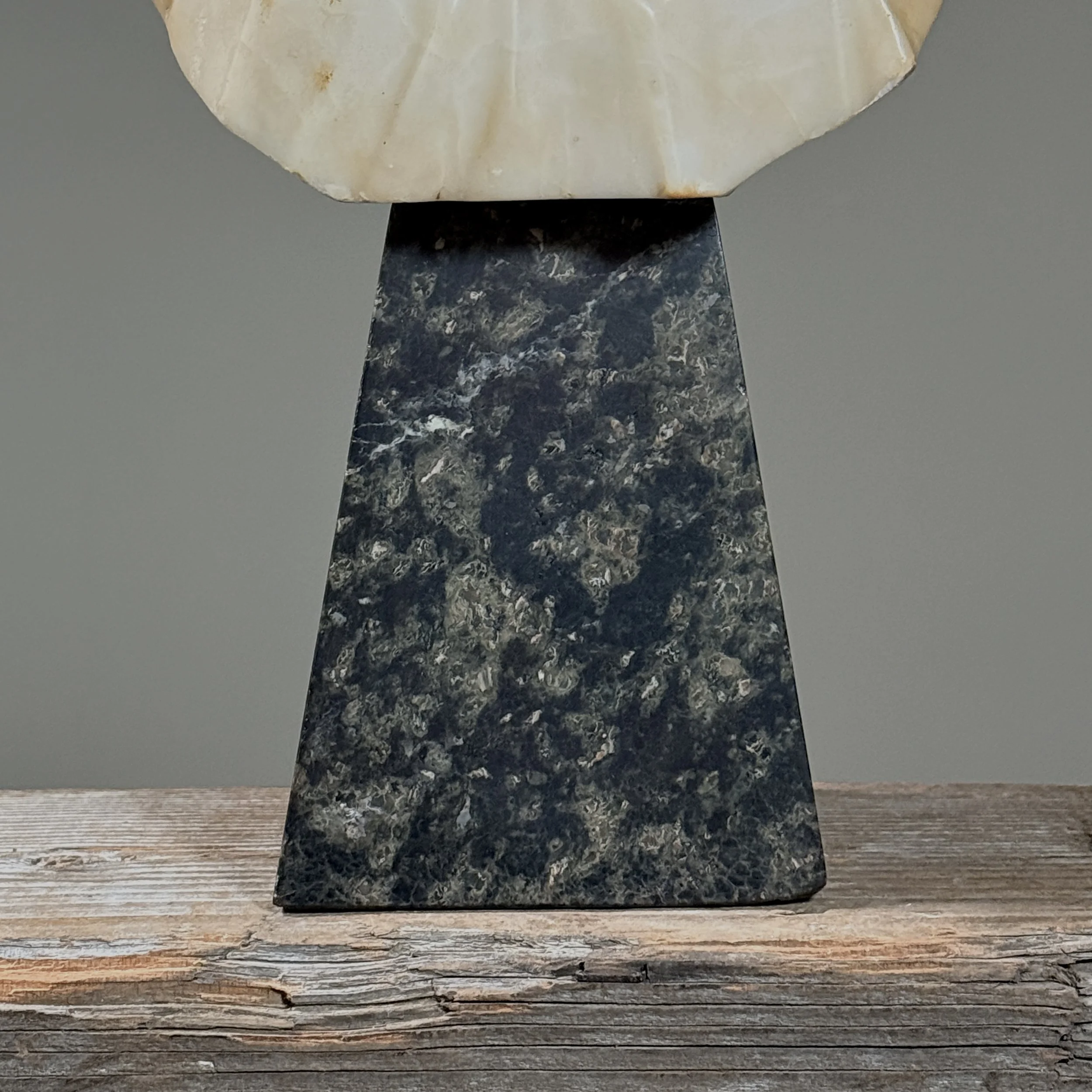 Detail of the marble base's texture and distinctive speckled patterning.