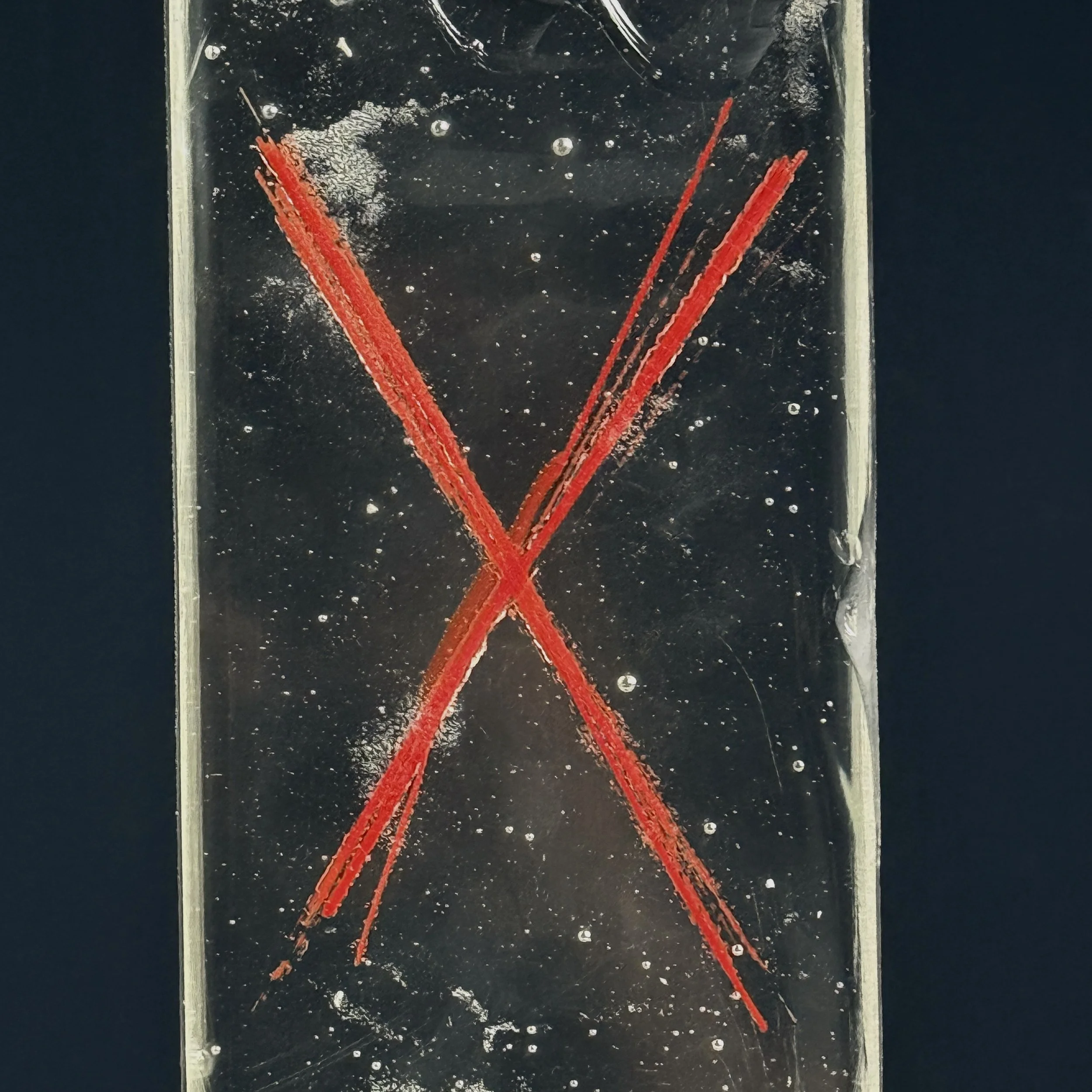 Detail of red X pattern across translucent glass plane