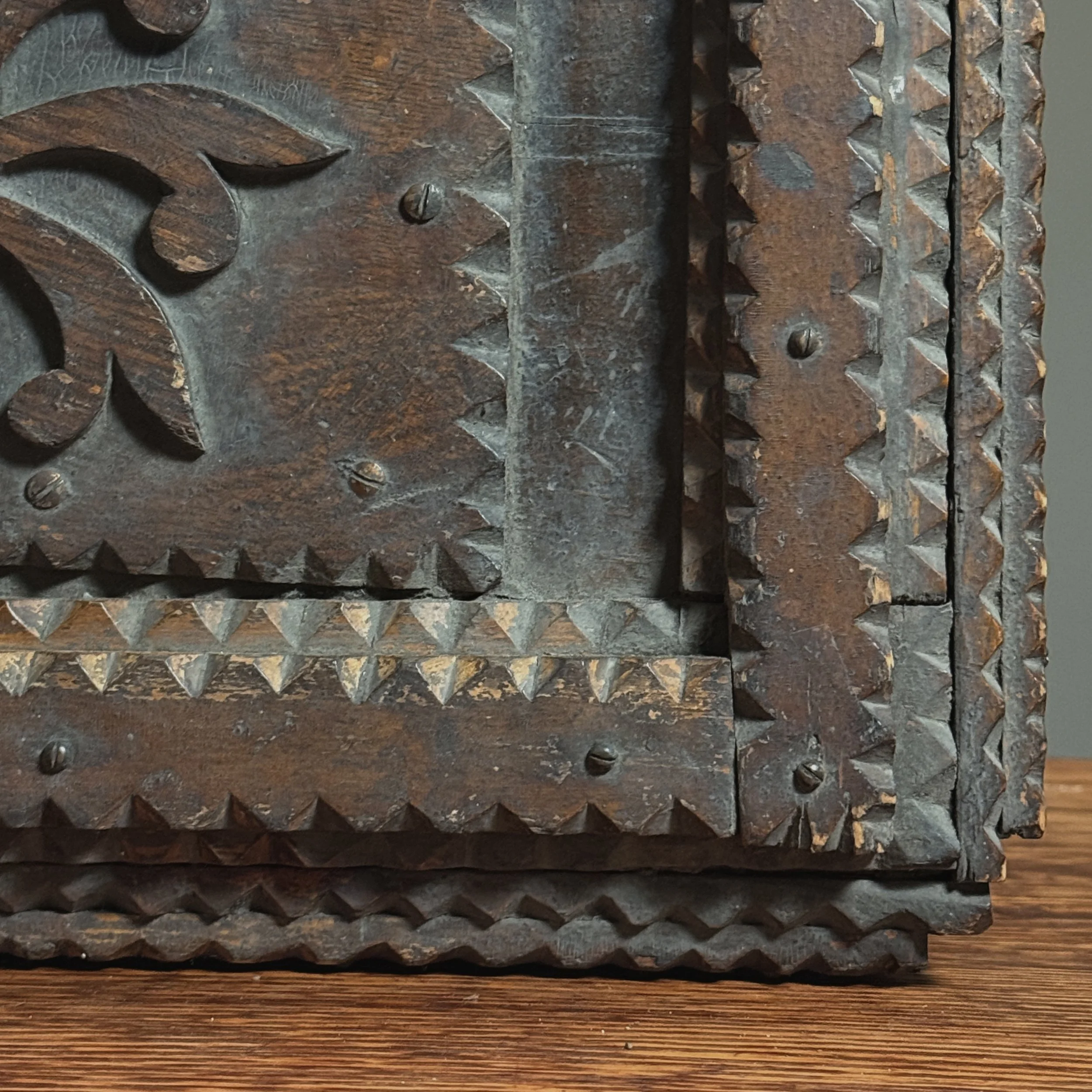 Close-up of the layered wood and notch-carving technique on the chest's edge.