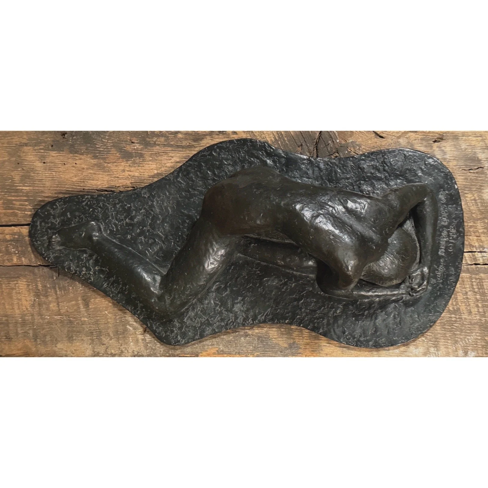Overhead view of reclining bronze nude sculpture in Rodin style