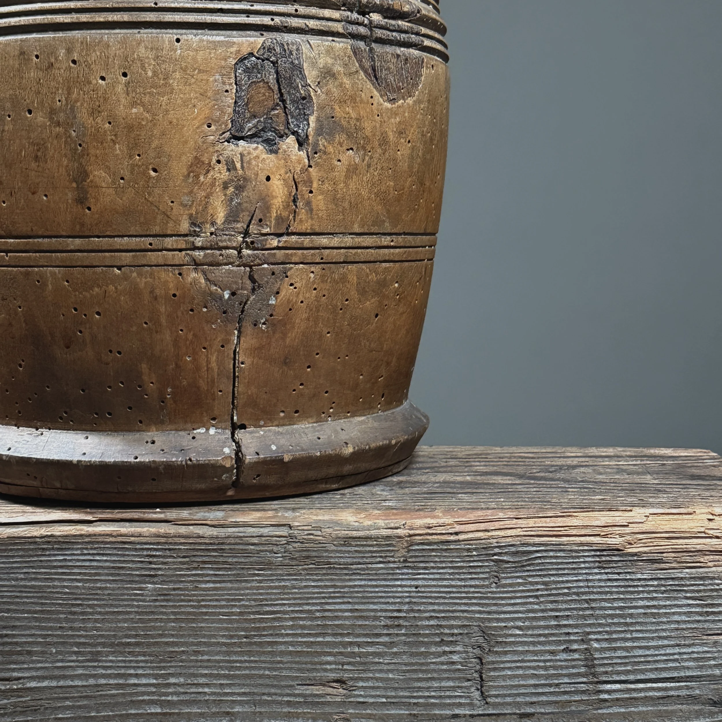 Front view of antique treenware barrel with concentric ribbed bands