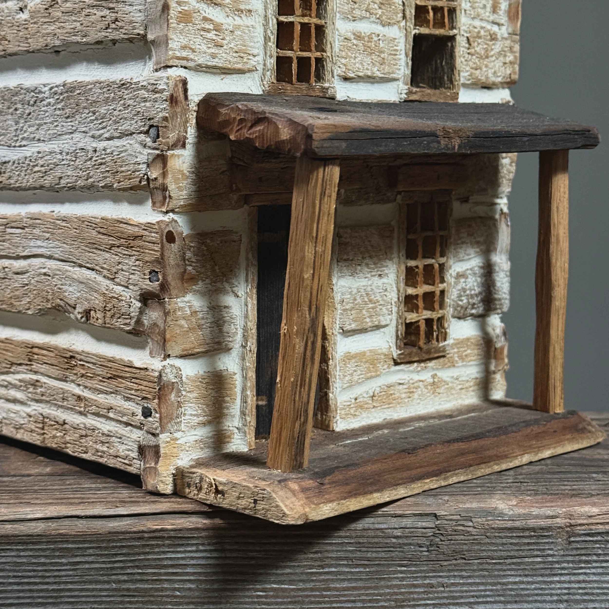Close-up of aged surface and patina on vintage folk art country home miniature.