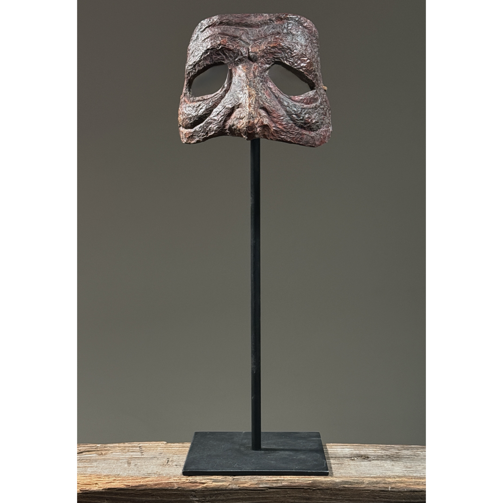 Front view of deep red papier-mâché Commedia Harlequin mask.