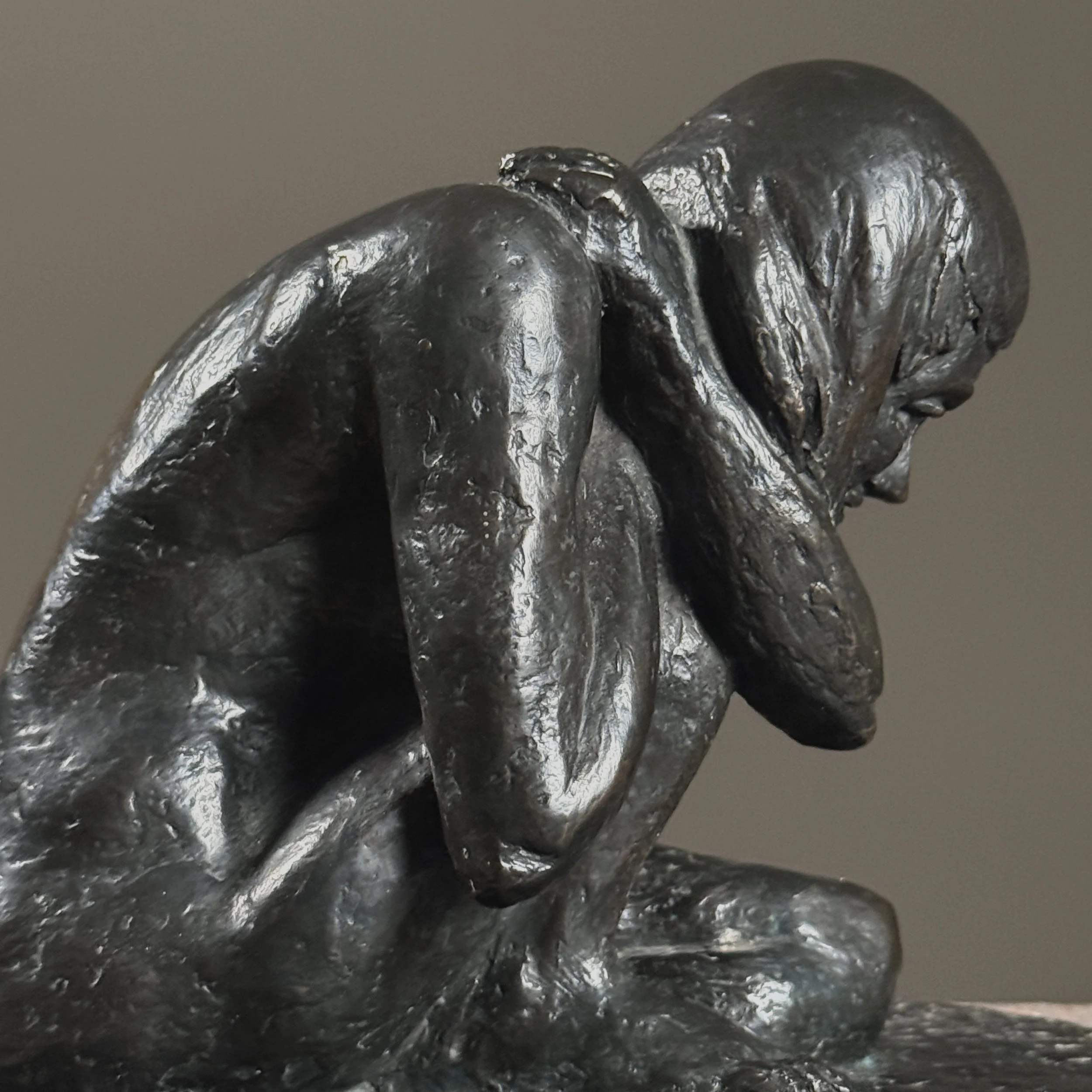 Close-up detail of the crouching nude's form and naturalistic anatomical modeling