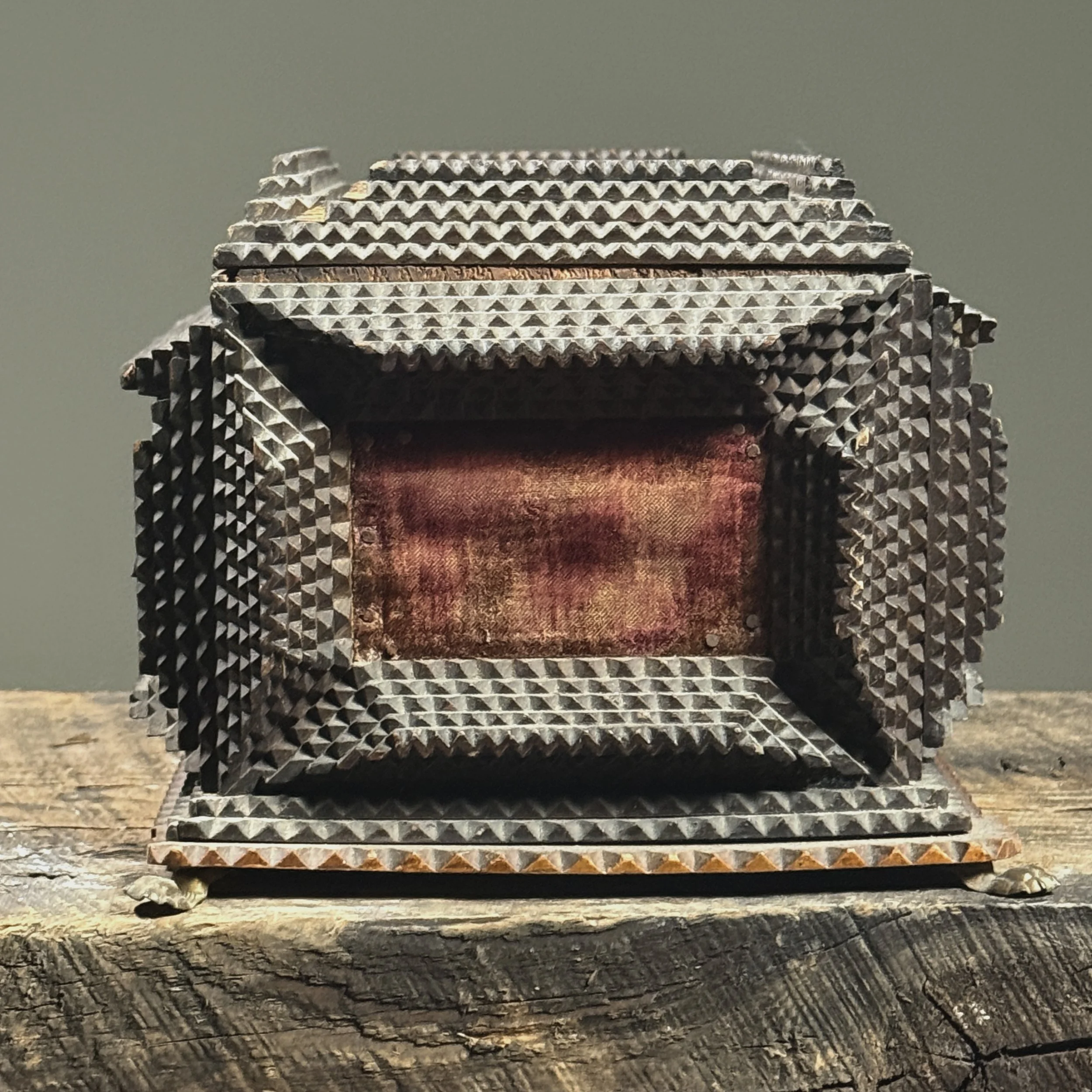 Side view of the box with velvet panel and carved detail.