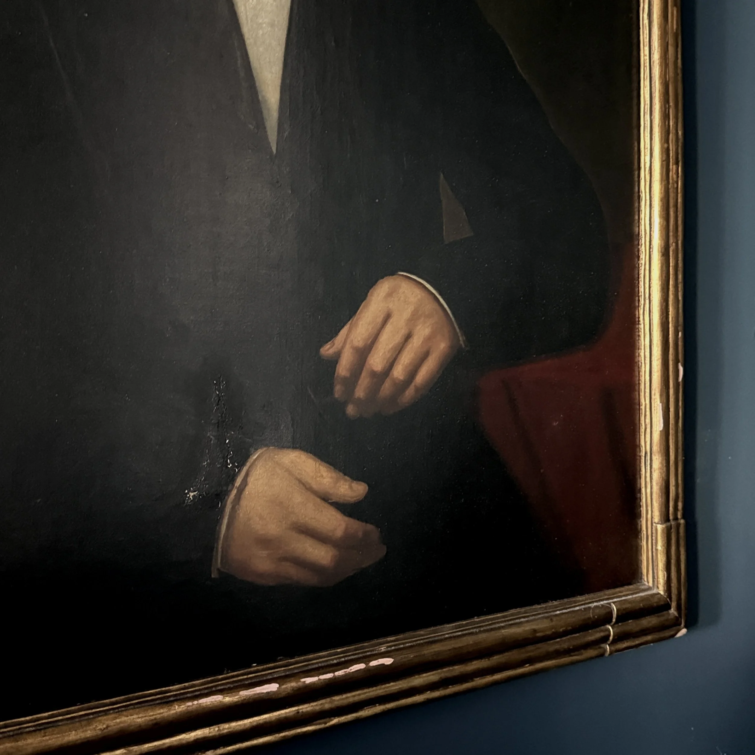Detail of canvas abrasion and surface disruption near the sitter's proper right hand and cuff.
