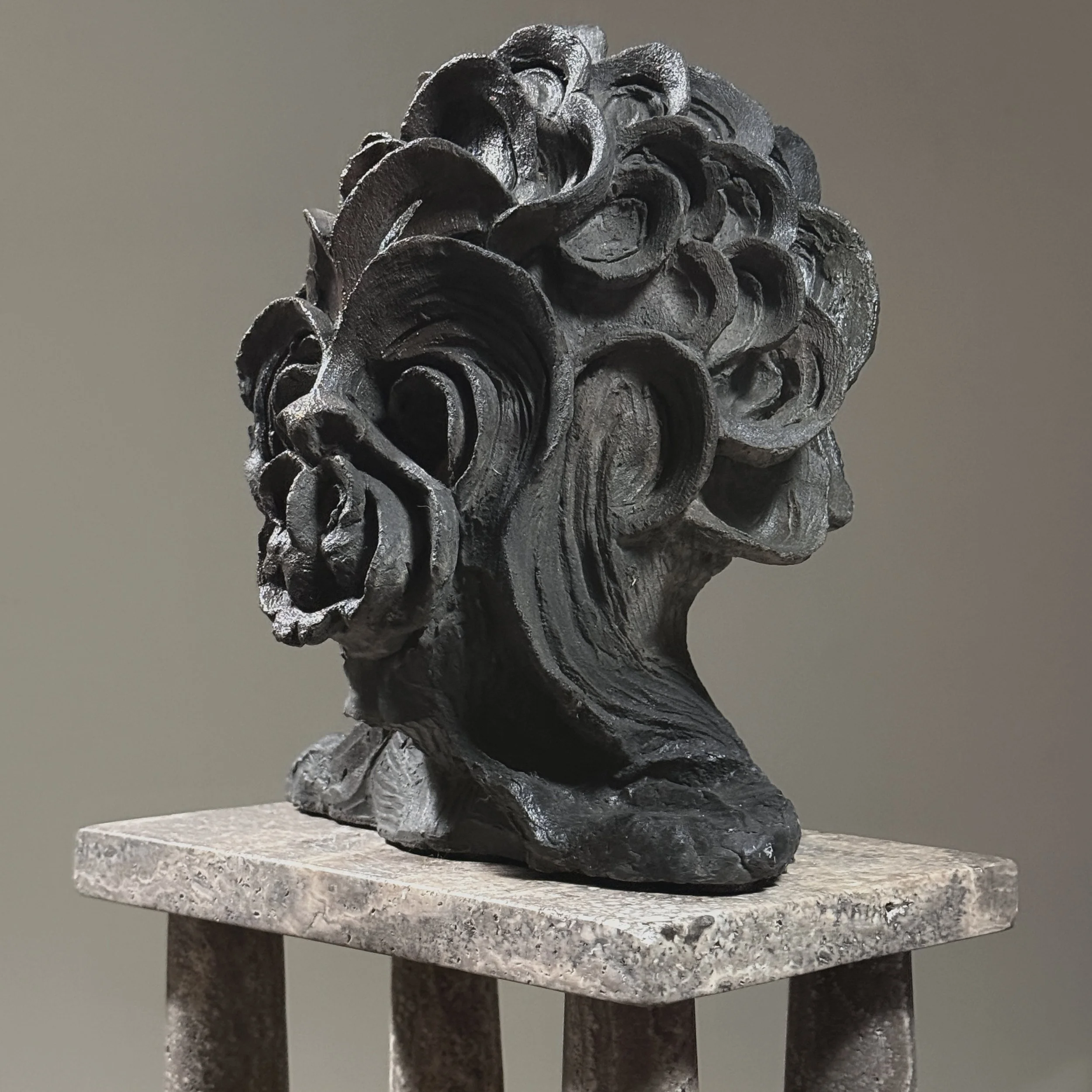 Three-quarter view. Sculpture weight and density visible. Hand-modeled texture.