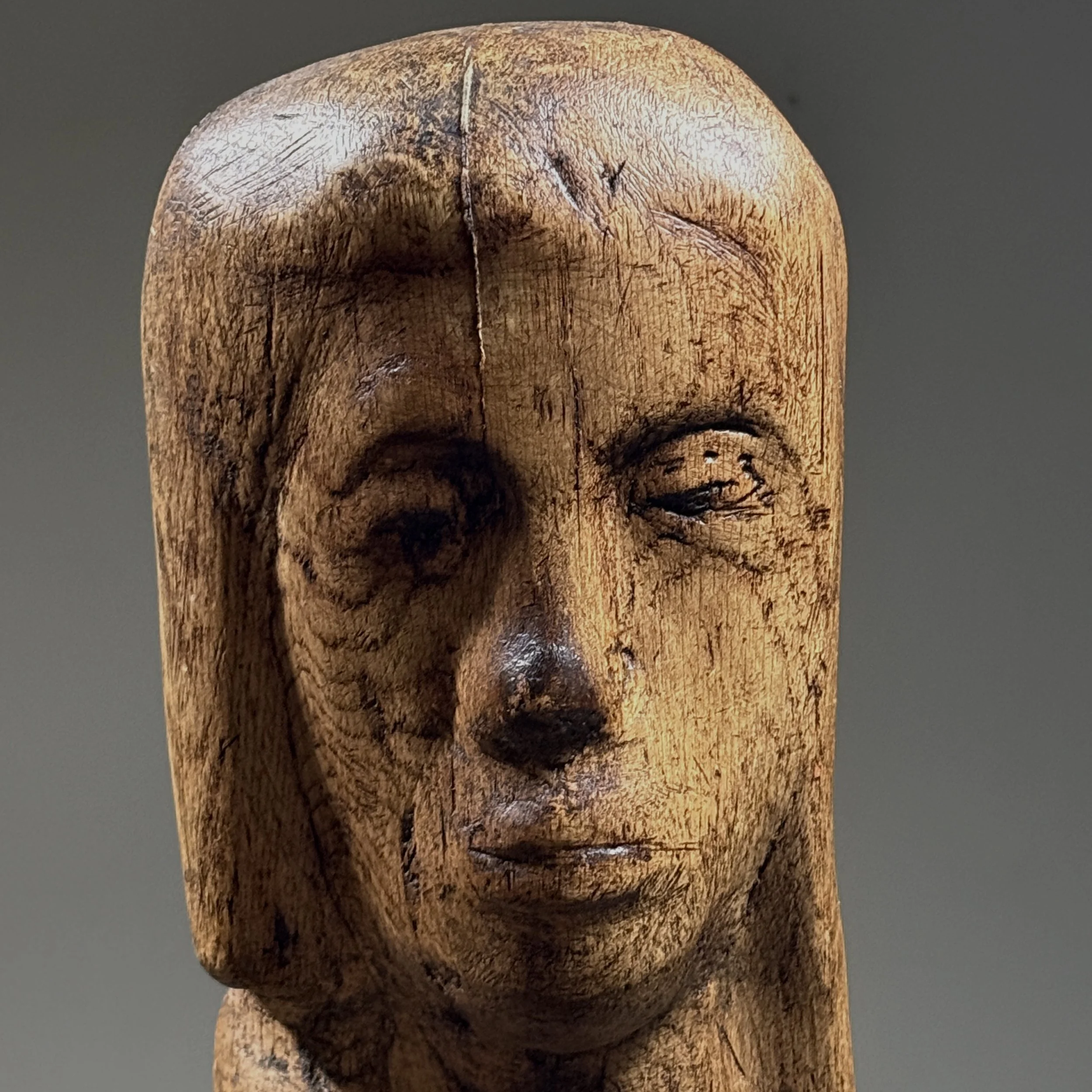 Close-up detail of face and carving on vintage hand carved Folk Art Modernist portrait bust, wood